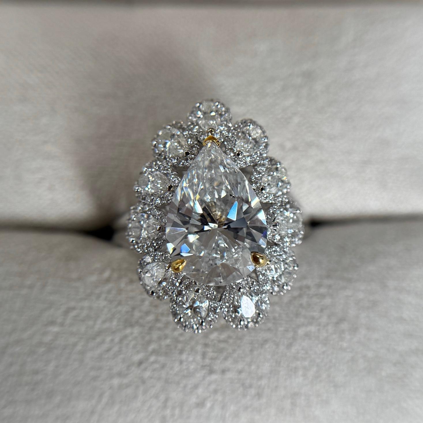 Rayonnante et élégante, cette bague de collection de Revive Jewels met en valeur un diamant naturel de 3,03ct en forme de poire certifié par GIA, classé H SI1 (percé au laser). Sertie dans un gracieux halo en forme de poire, la pierre centrale est