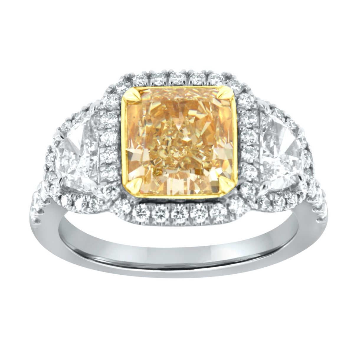 This spectacular Platinum and 18k Yellow gold ring features a 3.04 Carat Square Cushion nearly flawless Yellow diamond GIA certified encircled by a halo of perfectly matched diamonds and flanked by two half-moon diamonds in weight of 0.71 carats.