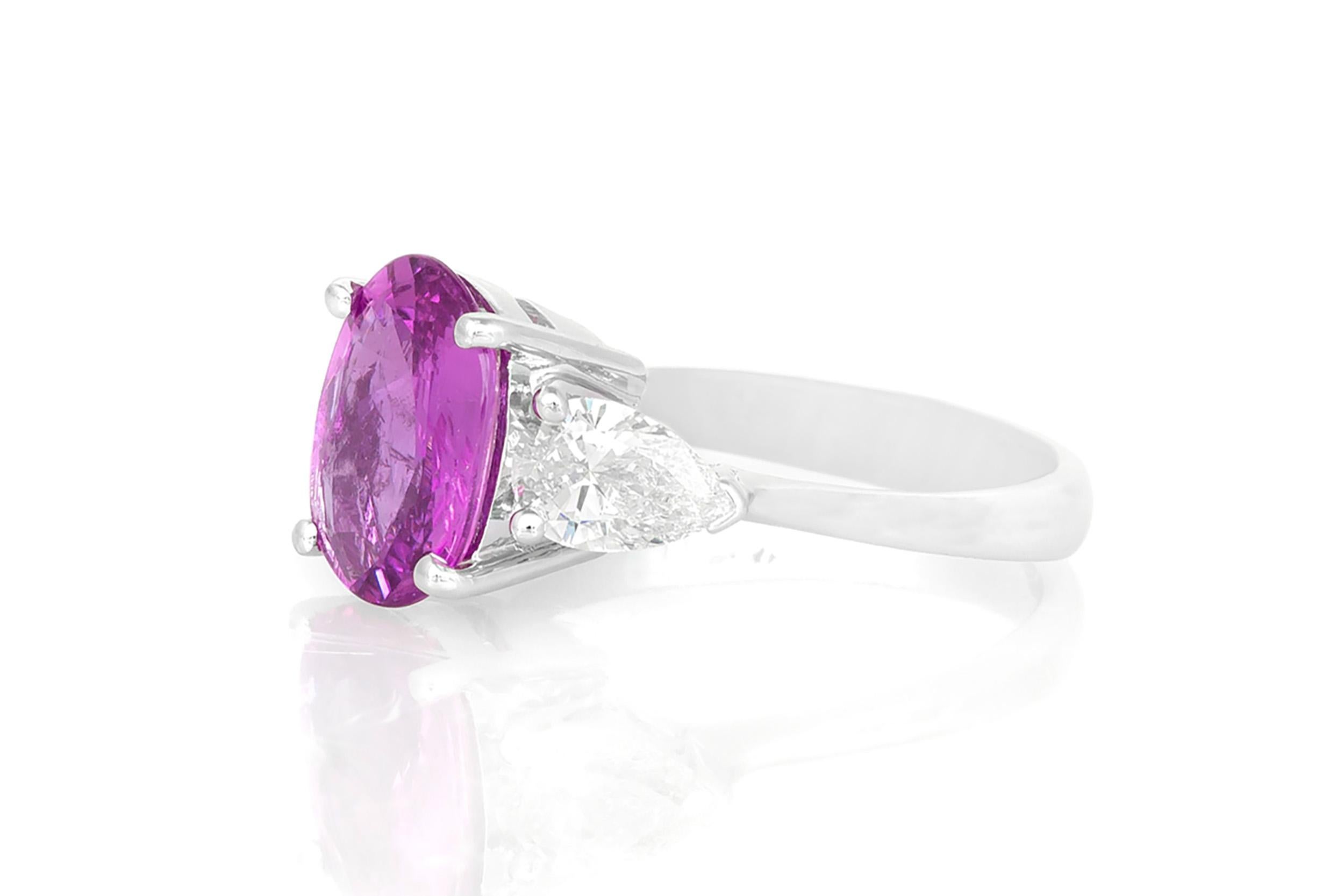 Finely crafted in 18K white gold with an Oval cut Pink Sapphire weighing approximately 3.04 carats, accented by a pair of Pear-Shaped Diamonds weighing a total of approximately 1.05 carat.
Size 6 3/4, resizable