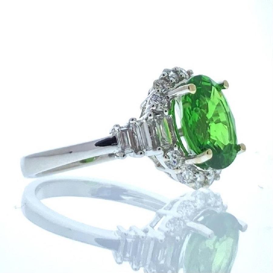 This exquisite ring is a testament to sophistication and refinement. Crafted in 14 karat white gold, it features a stunning 3.04 carat oval-shaped tsavorite as its focal point. The vibrant green hue of the tsavorite is captivating, evoking a sense