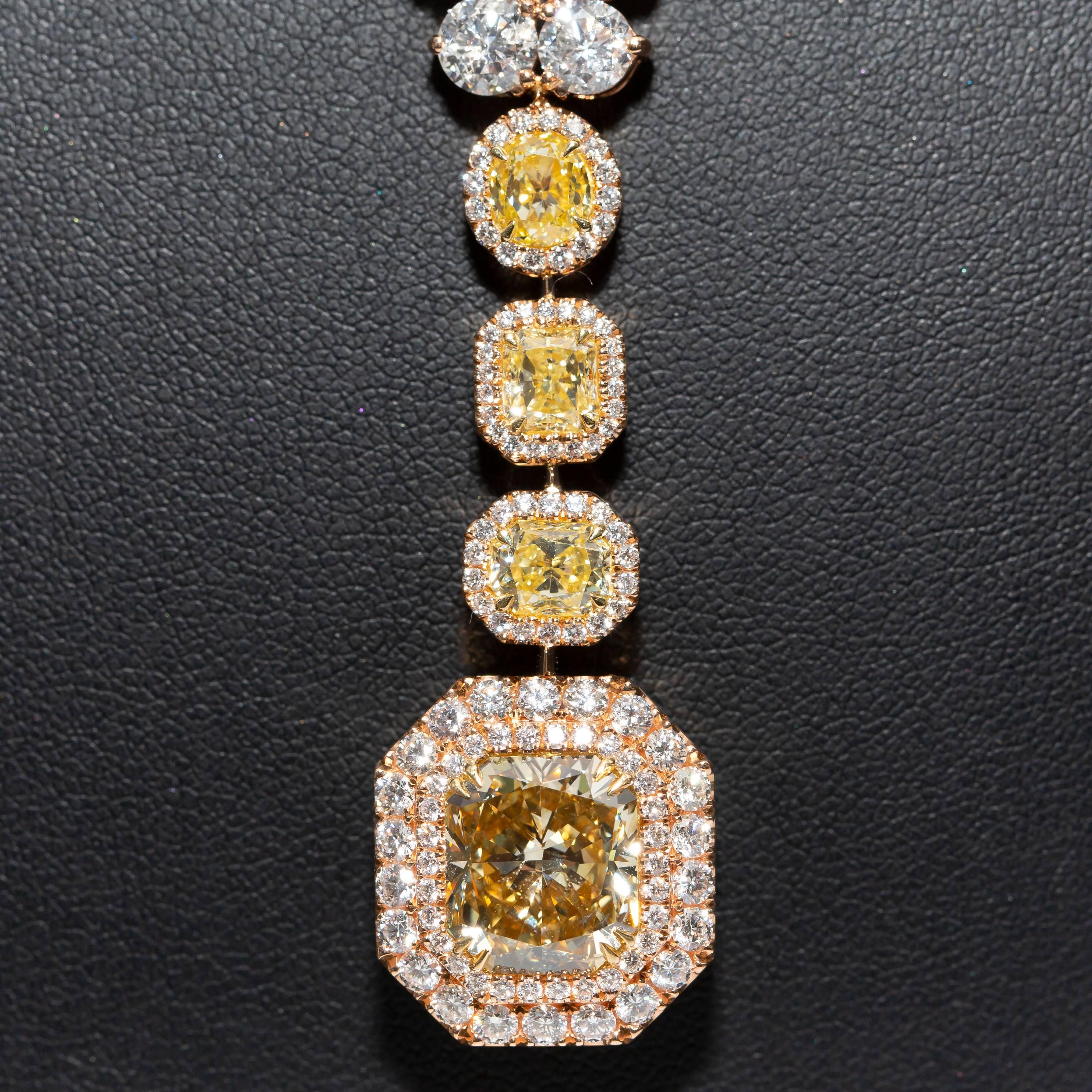 GIA certified center stone 6.06 Carats Fancy Deep Brownish Yellow, clarity SI2 surrounded by double Halo of White Diamonds, complimented with three mixed shapes Yellow Diamonds (Y-Z VS2) Round, Radiant and Cushion cut. The total weight of the three