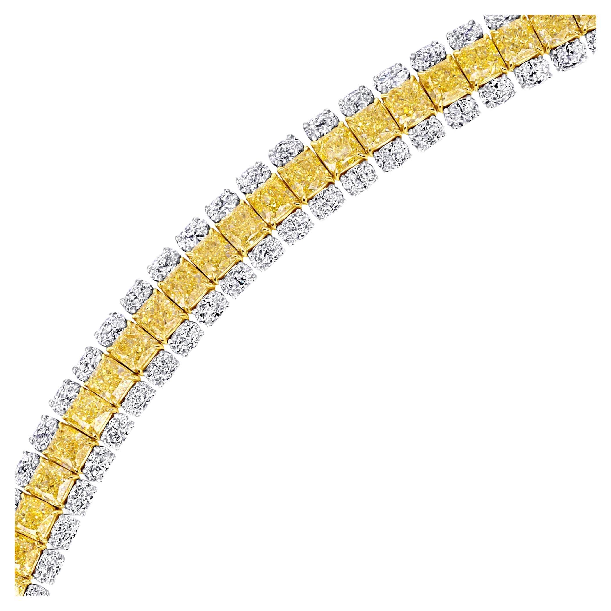 This three-row tennis bracelet features forty radiant cut Fancy Intense Yellow diamonds weigh 21.24 carats and eighty oval-cut diamonds weigh 9.22 carats, set in 18K Yellow Gold and Platinum. The contrasting colors and cuts create a truly unique and
