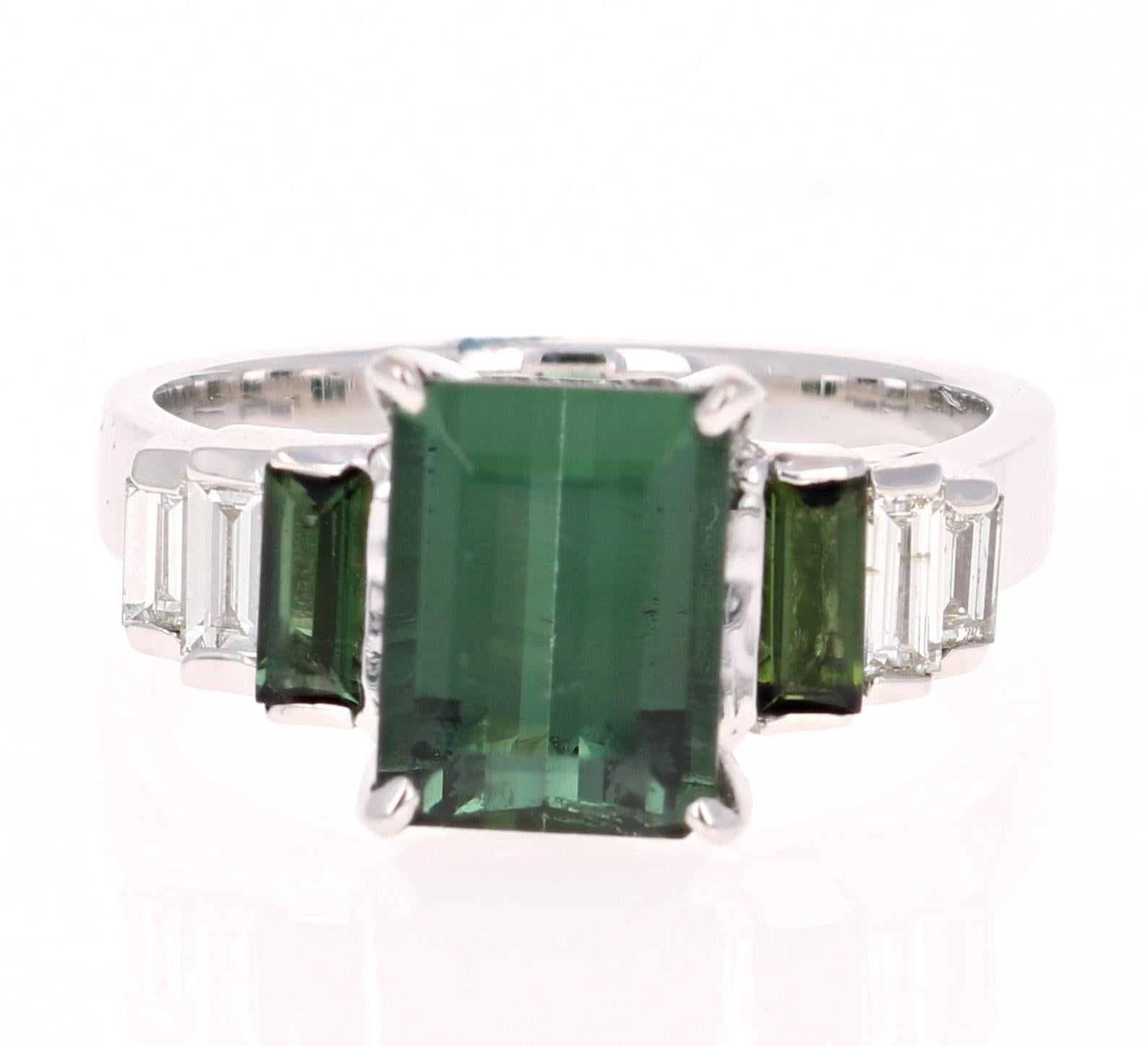 A unique beauty that is sure to be a rare and gorgeous design! Very much inspired by the articulate designs of the art-deco era.

This stunner has a Emerald Cut Green Tourmaline that weighs 2.41 Carats. Adjacent to the tourmaline are 2 Baguette Cut