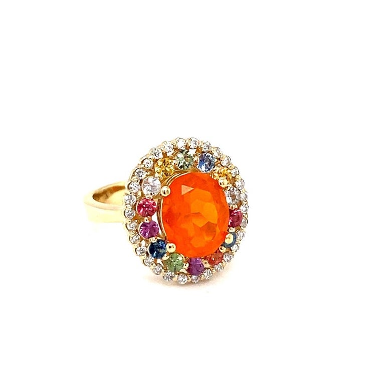 This ring has a 1.86 carat Oval Cut Orange Fire Opal as its center stone and is elegantly surrounded by 14 Multi-Colored Sapphires that weigh 0.91 carats and 30 Round Cut White Diamonds that weigh 0.28 carats. (Clarity: SI2, Color: F)
The total