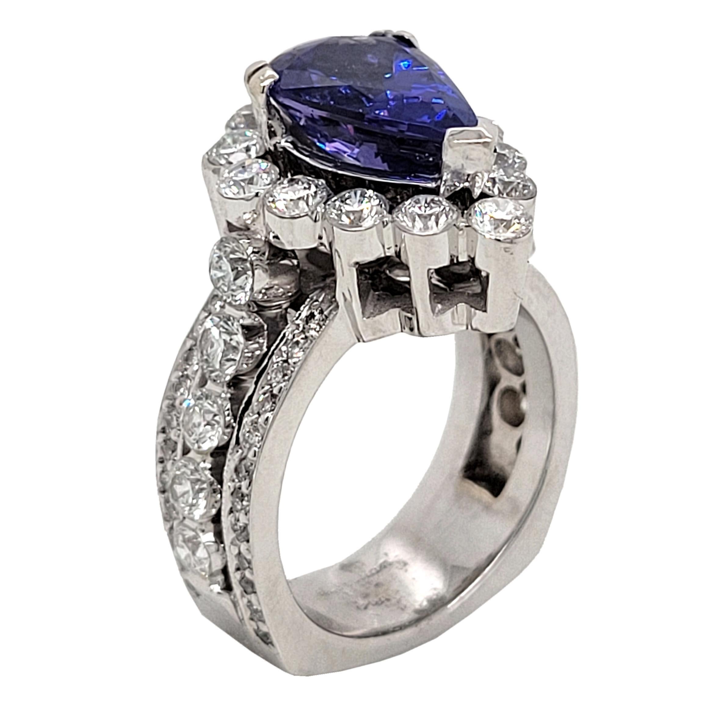 A  Beautiful Color 3.05 Ct Pear Shaped Tanzanite set in a gorgeous 18k gold  Pave/Invisible set engagement Ring with halo and total diamond weight of 2.45 Ct. on the side.  The ring has a squared Shank.

Center stone: 3.05 Ct Pear shape