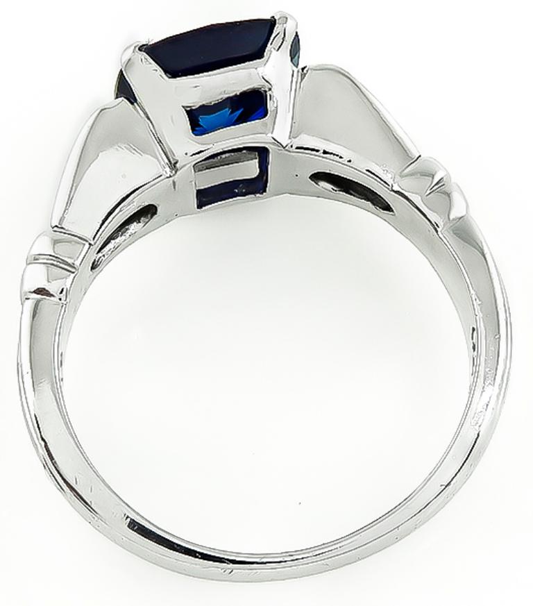 This stunning platinum engagement ring is centered with a lovely cushion cut Ceylon sapphire that weighs 3.05ct. The sapphire is accentuated by sparkling baguette cut diamonds that weigh approximately 0.25ct. graded G color with VS clarity. The ring