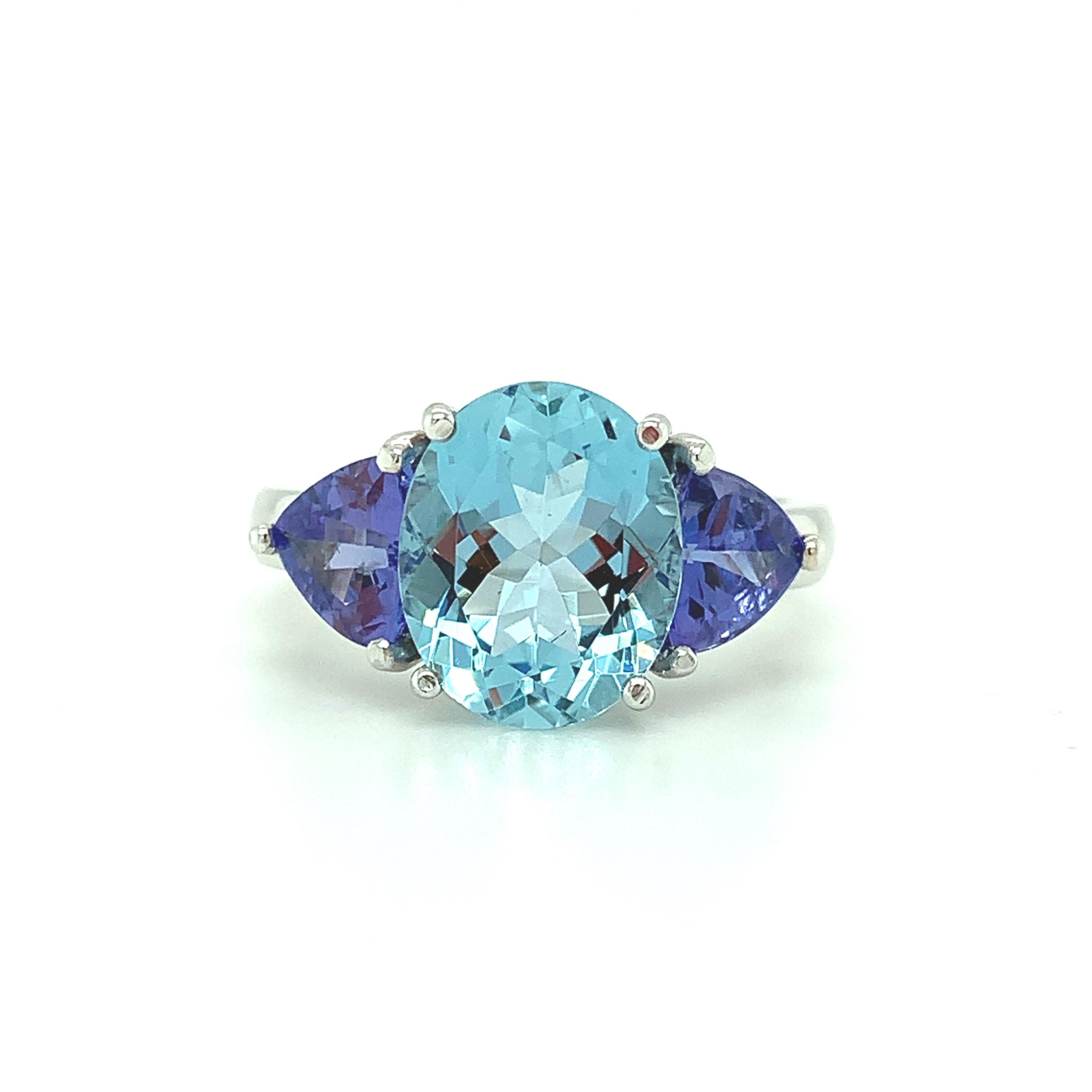 A vivid, Tahitian-blue aquamarine is paired with lavender-blue tanzanites in this beautiful 18k white gold cocktail ring. The aquamarine is a gorgeous, faceted oval with extraordinary clarity and brilliance. The tanzanites are rich in color of the
