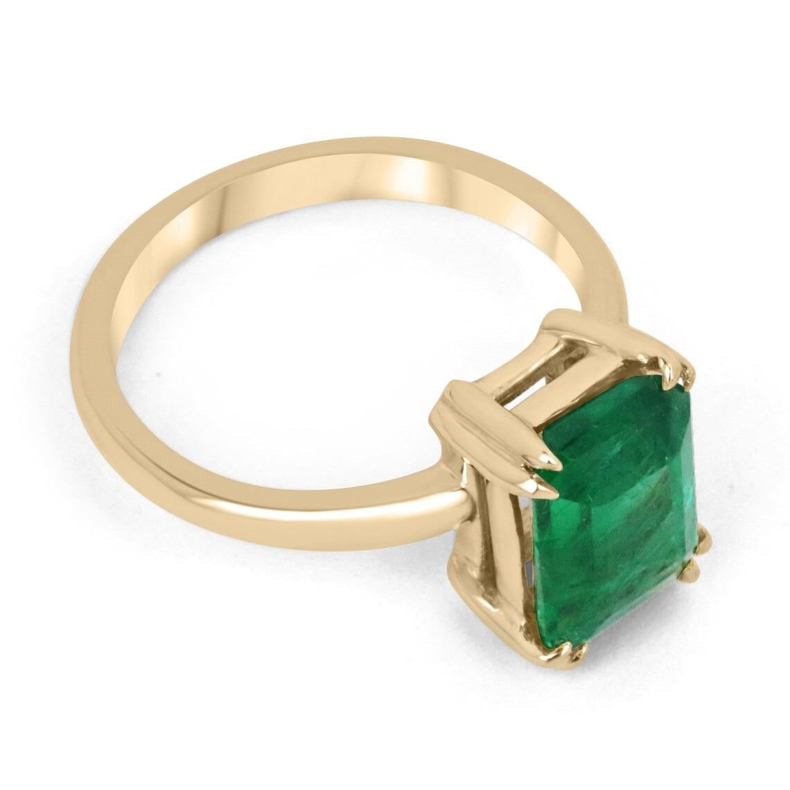 Displayed is a classic emerald solitaire engagement or right-hand ring. This spectacular piece features a remarkable 3.05-carat, natural emerald cut emerald from the origins of Zambia. The center stone showcases a rich, rare, dark vivid green color
