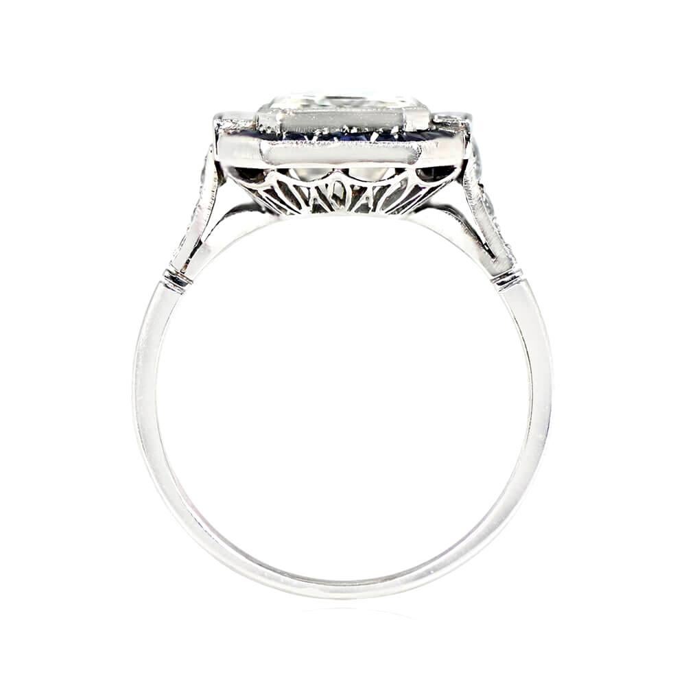 This is a stunning halo engagement ring featuring a 3.05-carat emerald cut diamond, L color, and VS1 clarity, set in a milgrain-decorated bezel. The center diamond is accented by two baguette-cut diamonds and framed by a halo of French-cut natural
