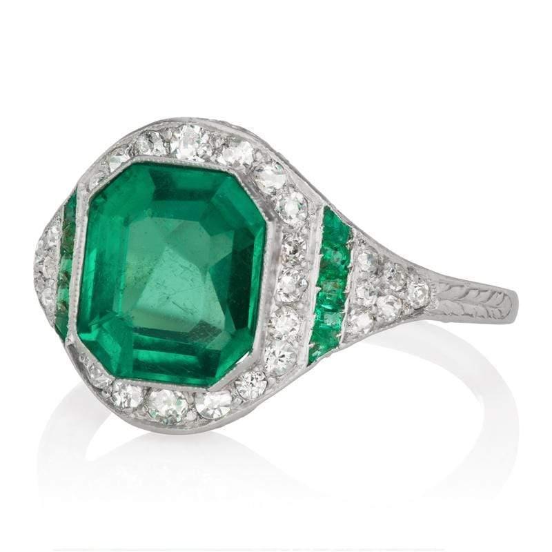 This ring is a French-made vintage emerald halo engagement ring from the Art Deco Era, circa 1920! This gorgeous creation features a GIA Certified 3.06 carat Asscher cut Colombian emerald with minor clarity enhancement. The stone is bezel-set in a