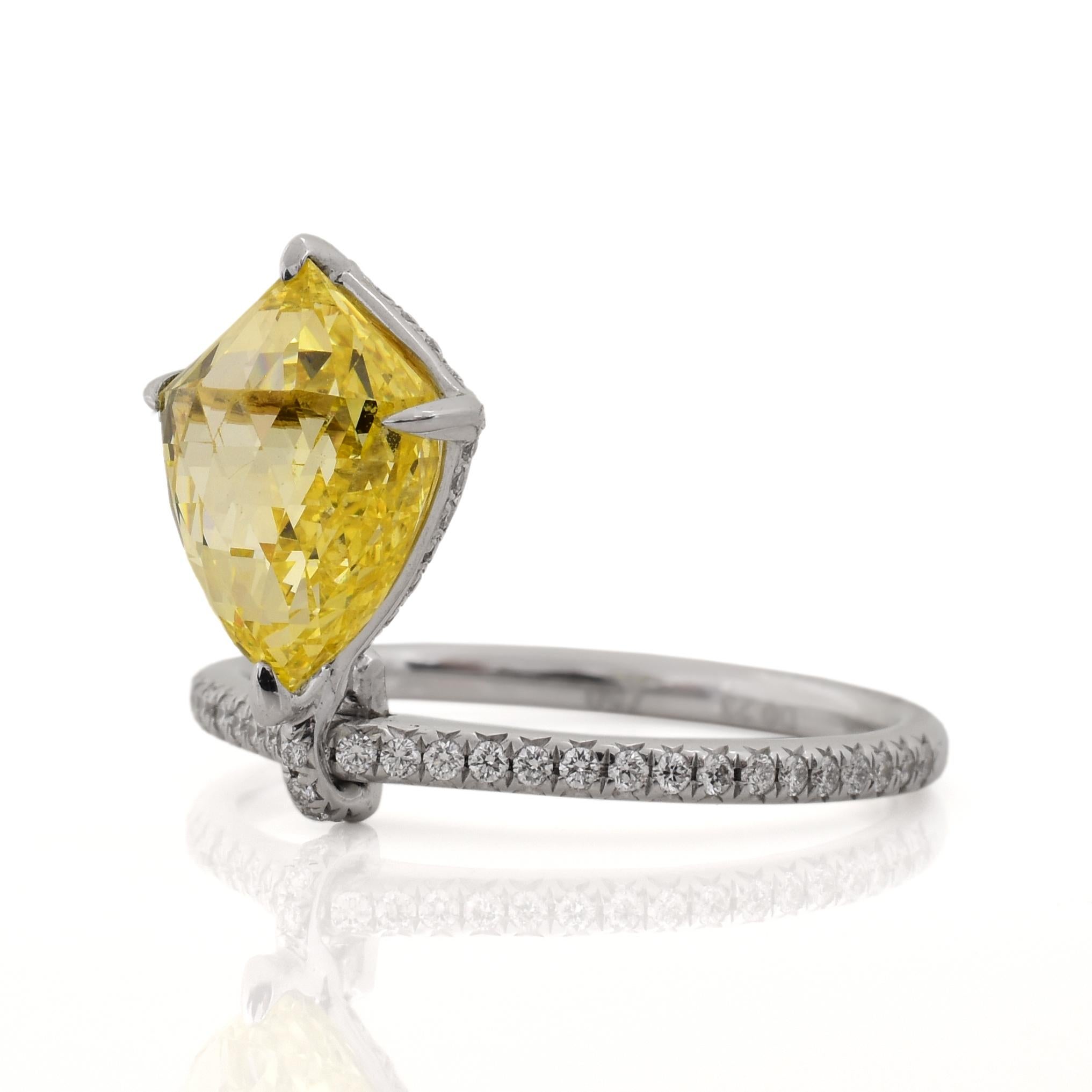 Very uniquely designed ring centering upon a 3.06ct GIA certified Fancy Intense Yellow Briollette center diamond (VS1 clarity). The ring contains approximately .50cts of round brilliant cut diamond sidestones on the shank and underneath the basket