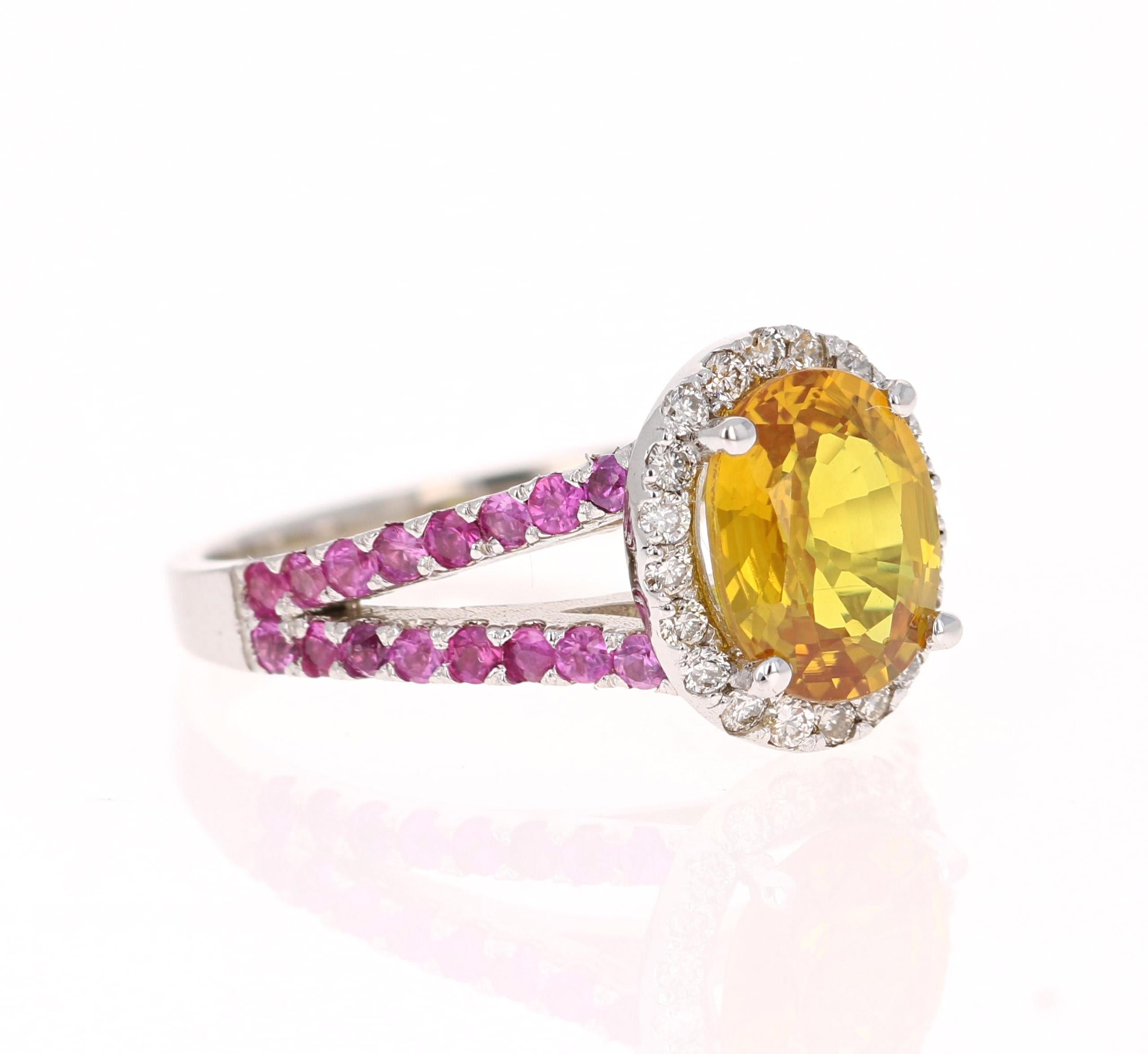 This beautiful ring has an Oval Cut Yellow Sapphire that weighs 2.17 Carats. It is surrounded by 22 Round Cut Diamonds that weigh 0.24 Carats. (Clarity: VS, Color: H) and it has Pink Sapphires on its shank that weigh 0.65 Carats. The total carat