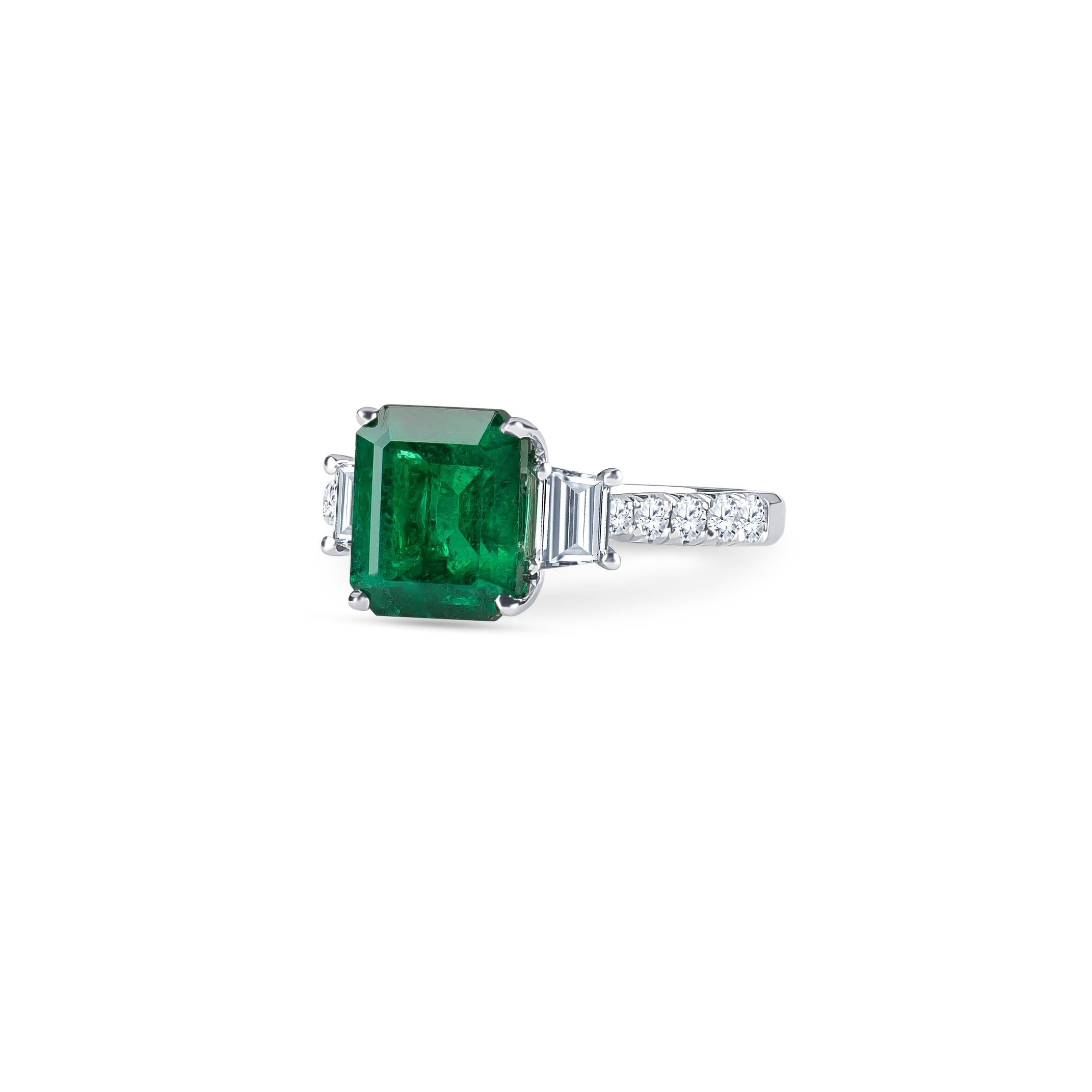 3.06 Carat  natural emerald (AGL certified) in emerald cut with 0.96 carats total weight of trapezoid step-cut & round brilliant diamonds, set in 18K white gold.  Ring size 6, may be resized to larger or smaller upon request. 