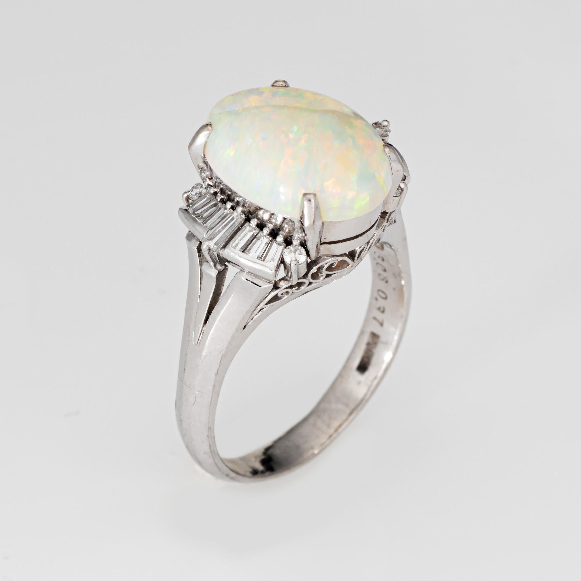 Stylish 3.06ct natural opal & diamond cocktail ring crafted in 850 platinum. 

Cabochon cut oval shaped natural opal measures 14mm x 10.5mm (3.06 carats). Diamond total an estimated 0.37 carats (estimated at I-J color and VS2-SI2 clarity). The opal