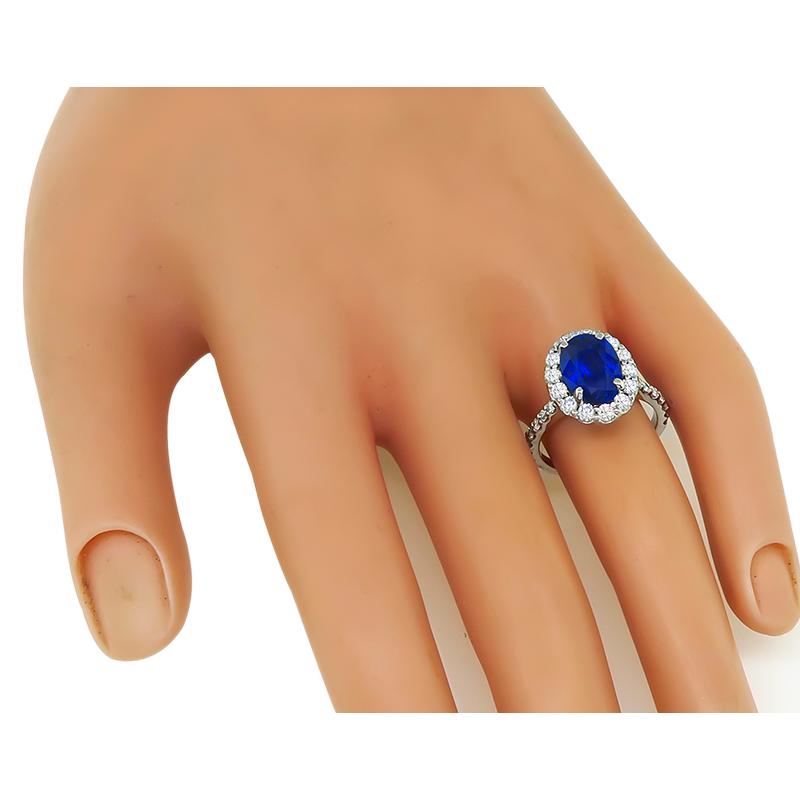 This is a charming 14k white gold engagement ring. The ring is centered with a lovely oval cut sapphire that weighs approximately 3.06ct. The sapphire is accentuated by sparkling round cut diamonds that weigh approximately 0.90ct. The color of these