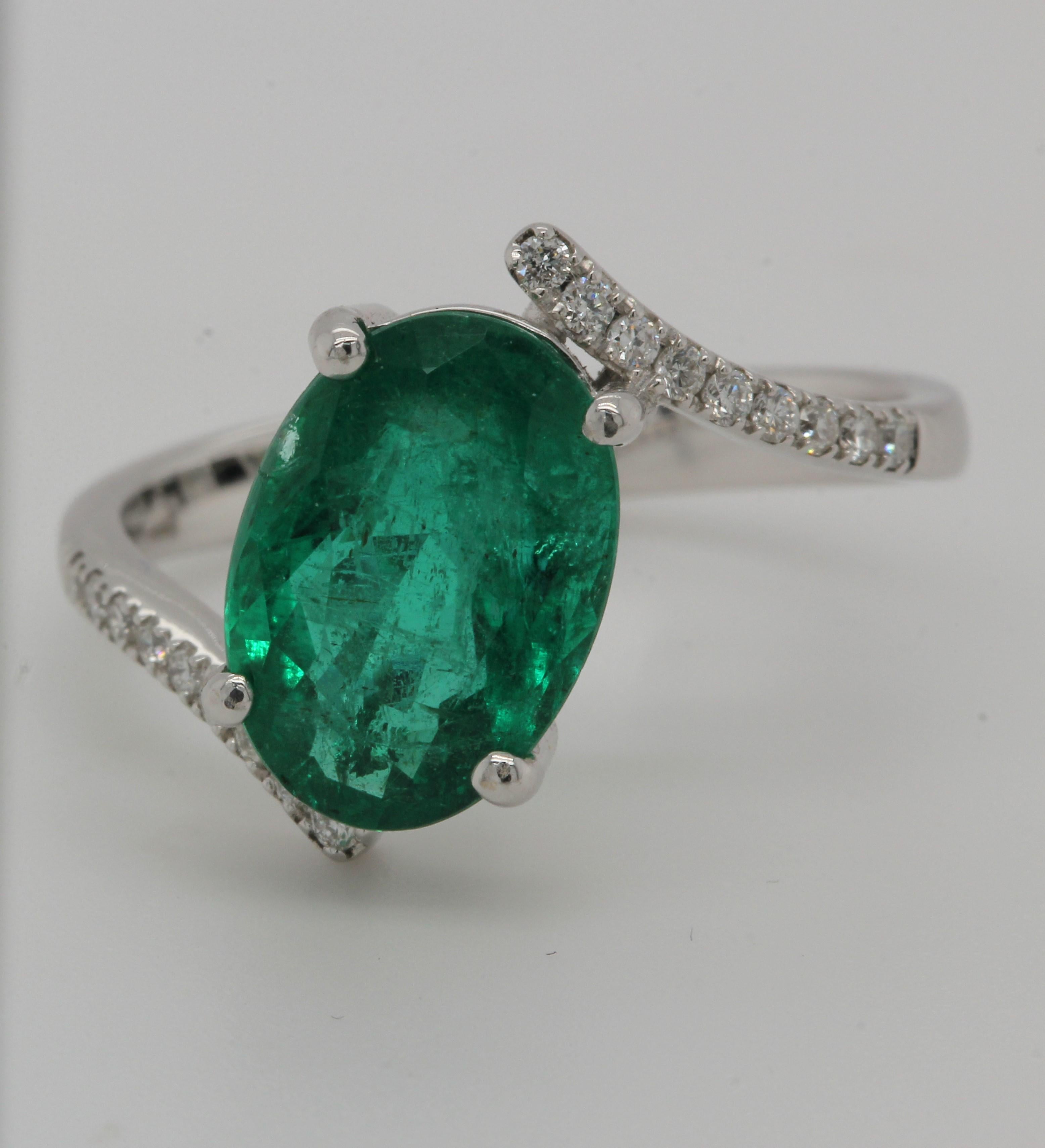 A perfect gift for a loved one, this emerald and diamond ring makes a strong statement. It's crafted from 18K white gold to be strong and sturdy, but with the elegance of a fine jewelry piece. The 3.07 carat oval emerald is surrounded by 0.14 carat