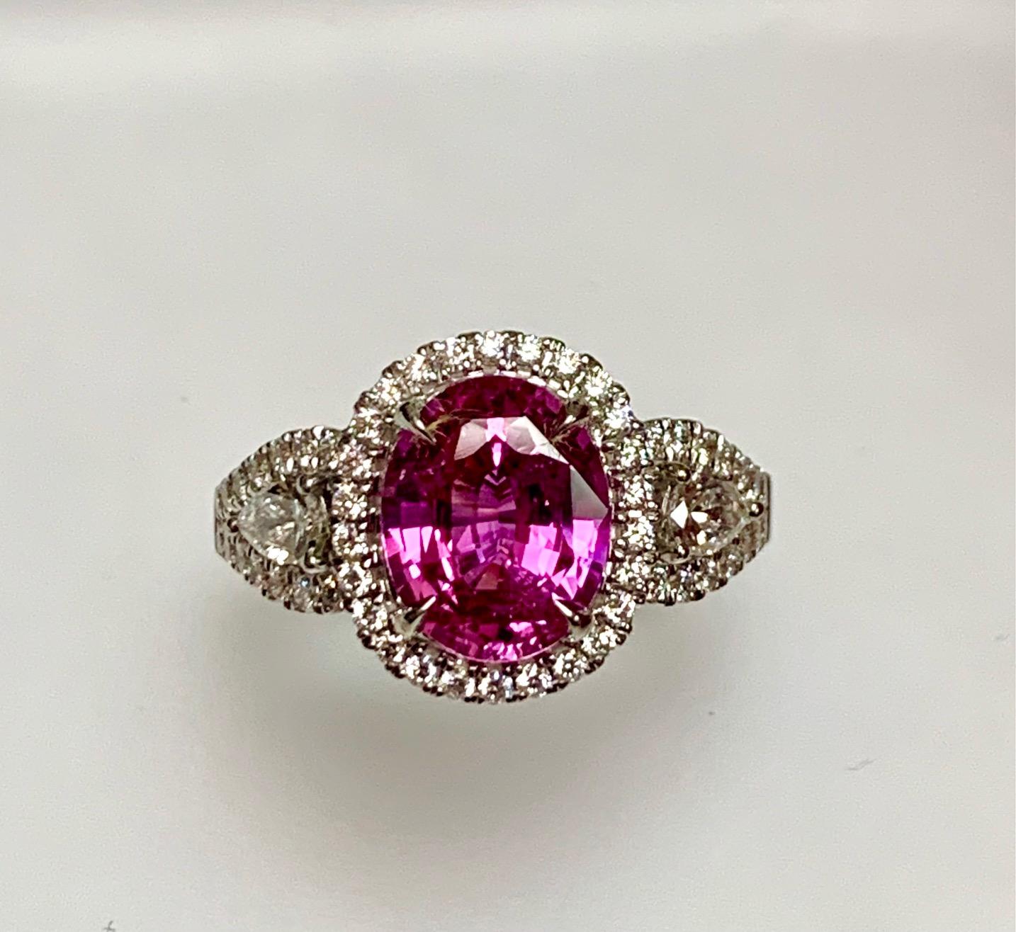 3.07 Carat oval pink sapphire set in 18k white gold ring with 0.78 carat round diamonds around it and on the shank and  pear shape diamonds on the split shank .