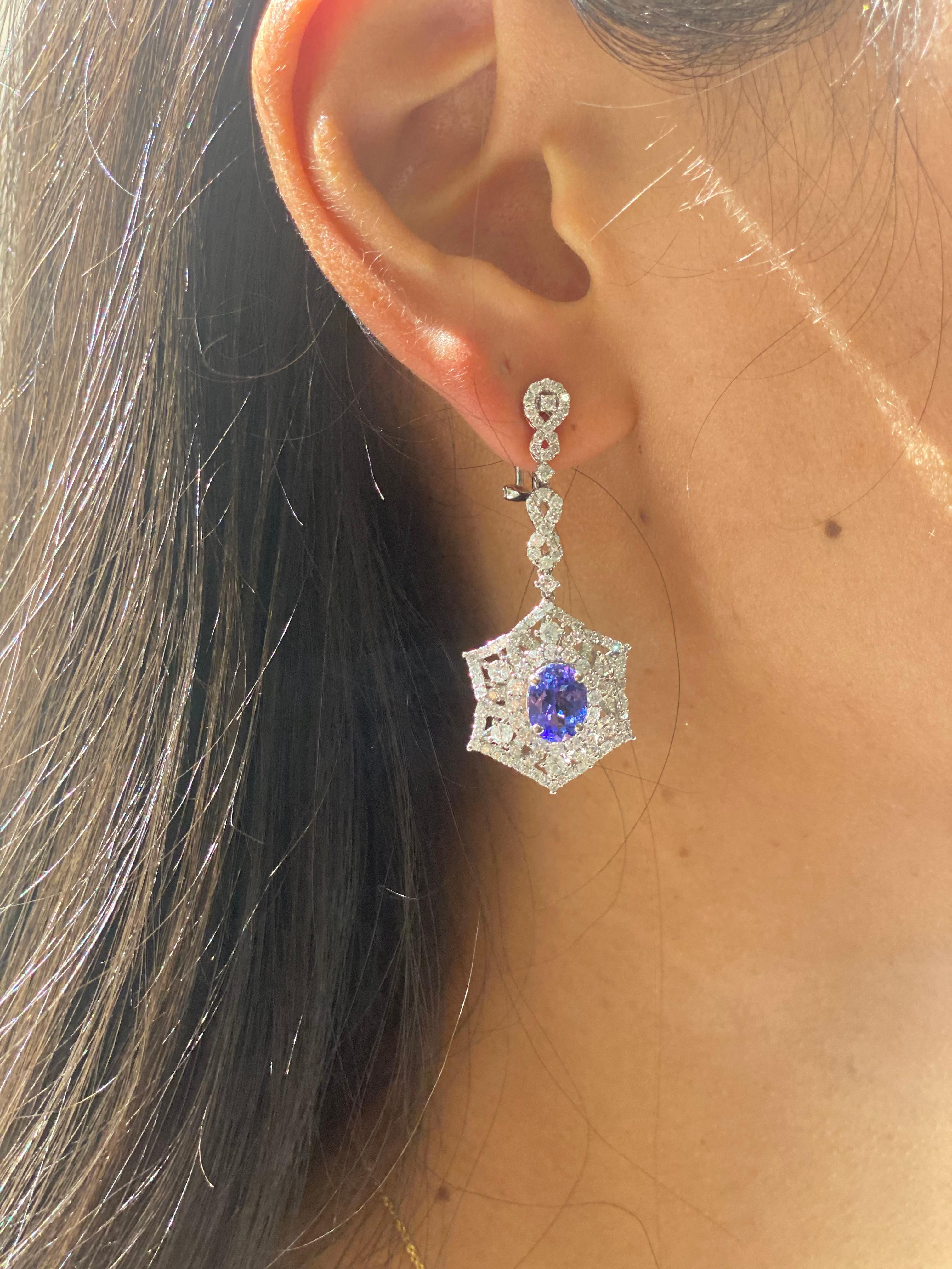 Oval cut Tanzanite centers with 3.07ct total weight, and 4.07 carats of diamonds creating elegant flower shape patterns surrounding the gem all set in a rich 18k white gold 

Details: 
weighs 11.8g
2” long 
