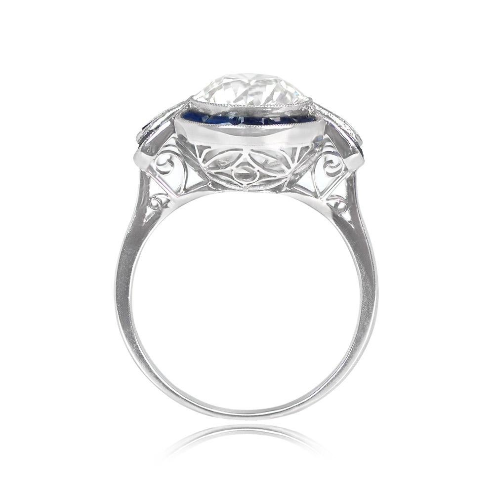 Presenting an exceptional ring adorned with a mesmerizing 3.07-carat old European cut diamond, radiating elegance with its K color and VS2 clarity. The center stone is lovingly bezel-set, encircled by a captivating geometric halo of caliber natural