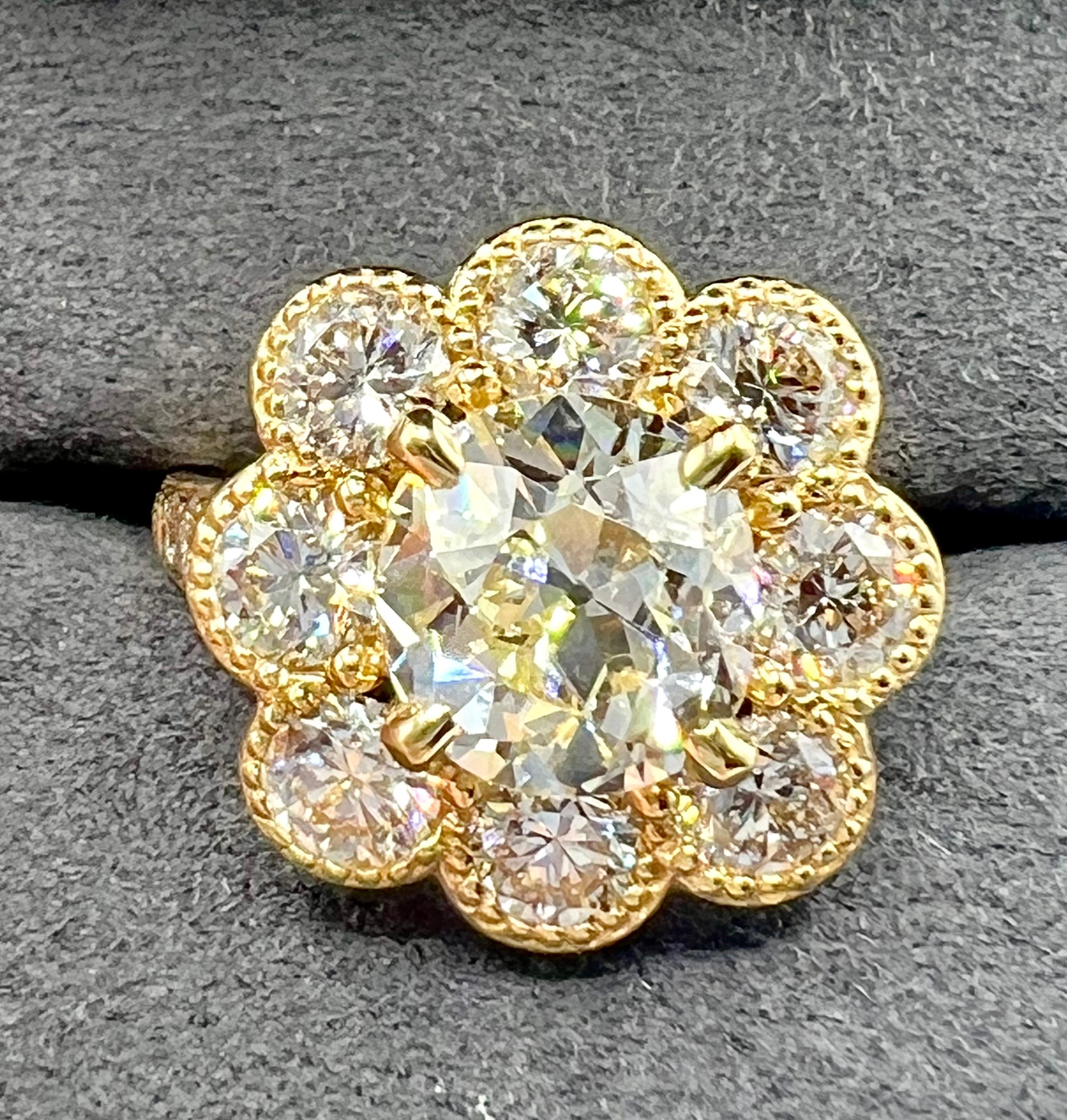 This exquisite flower-motif ring features a rare 3.08-carat old mine cut diamond (approx. 9.2 x 8.7mm, M color, VS clarity) as its stunning centerpiece. Set in warm 18K yellow gold, the central diamond is framed by a graceful floral halo of