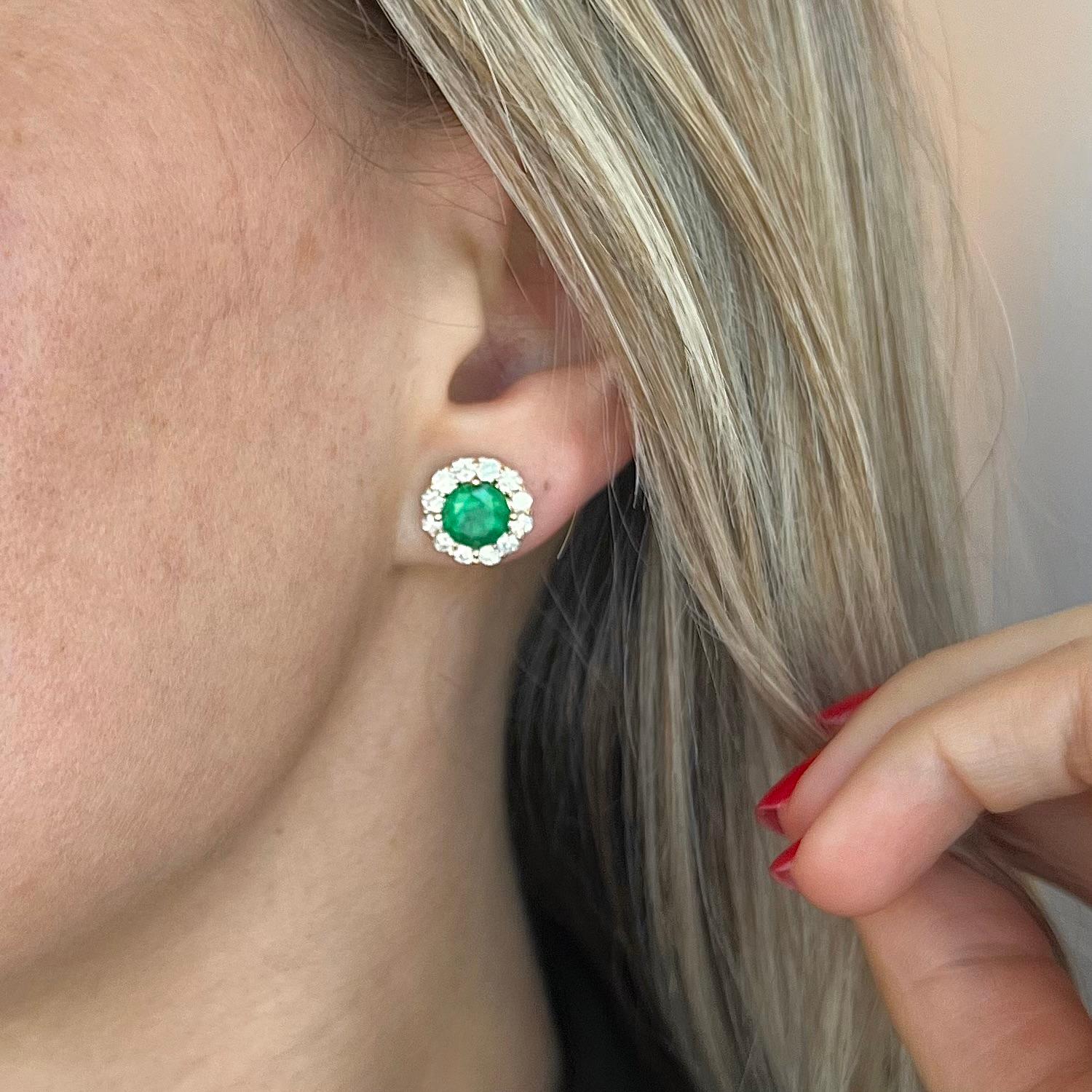 18 karat yellow gold Earth Mined emerald and diamond stud earrings. Featuring a stunning vivid green emerald in the center, encircled by top-quality earth mined diamonds.
The emerald weighs 3.08 carats and is the centerpiece of these earrings,