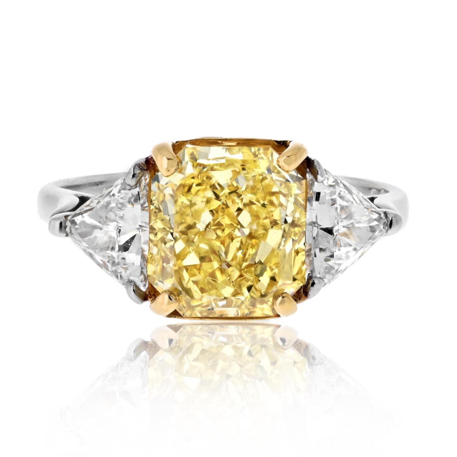 Illuminate your love story with this extraordinary 3.04ct Radiant Cut Fancy Intense Yellow Trilliant Cut Diamond Engagement Ring. The centerpiece, a radiant symbol of vibrancy, is a GIA certified Fancy Yellow Intense diamond, capturing the warmth of