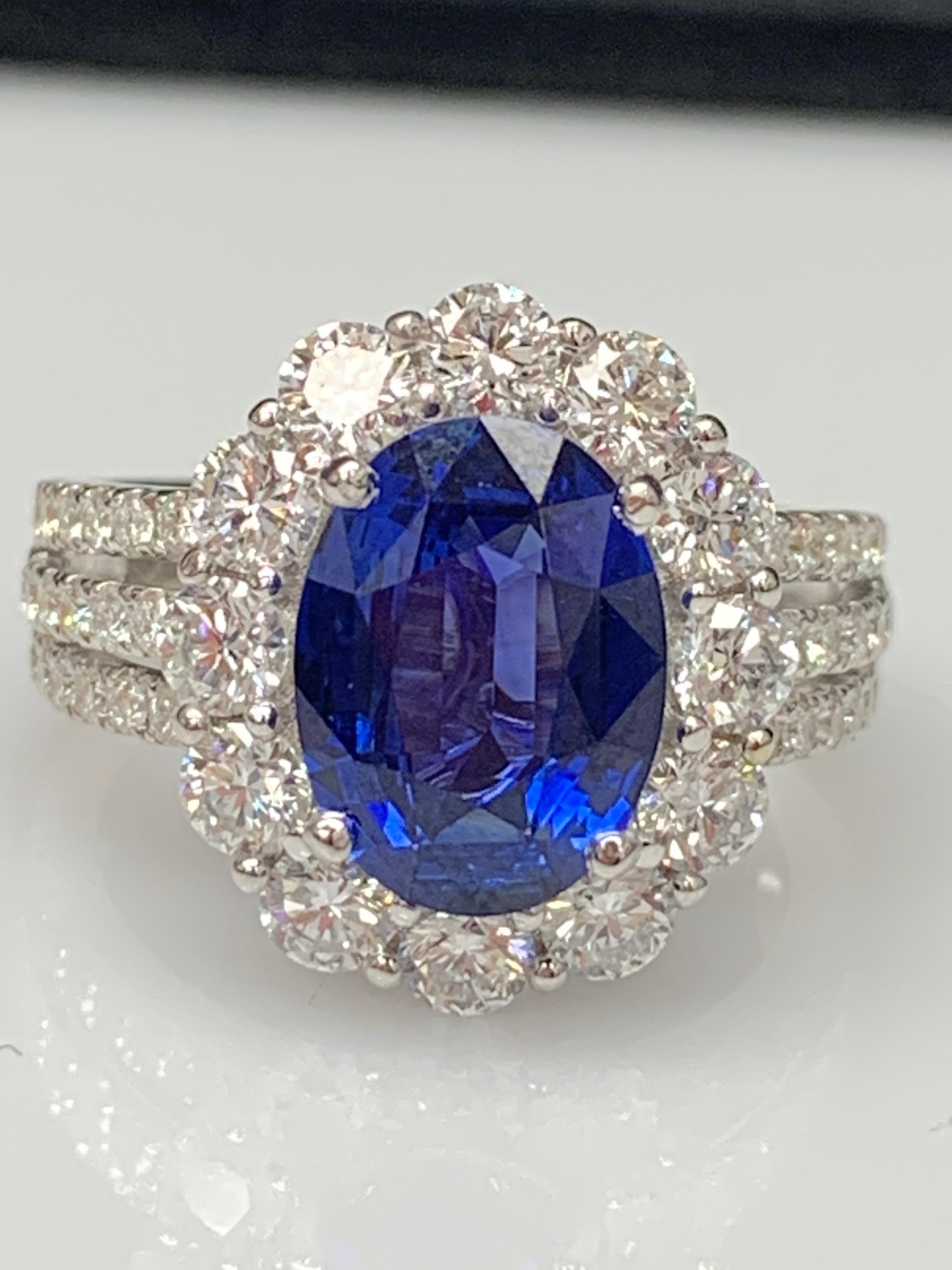 Features a beautiful 3.09-carat oval shape blue sapphire at the center. Surrounded by 12 brilliant-cut round diamonds weighing 1.32 carats in total. Diamonds are also set halfway all over the shank of the ring. The weight of the 46 accent diamonds
