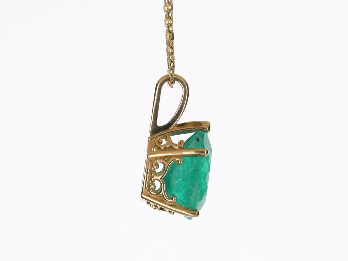 Featured here is an absolute classic! A solitaire Colombian emerald teardrop pendant. A full 3.09-carat Colombian pear cut emerald with a gleaming medium green color, and full of life. It is set in a custom, 5-prong, 14K yellow gold setting. Perfect
