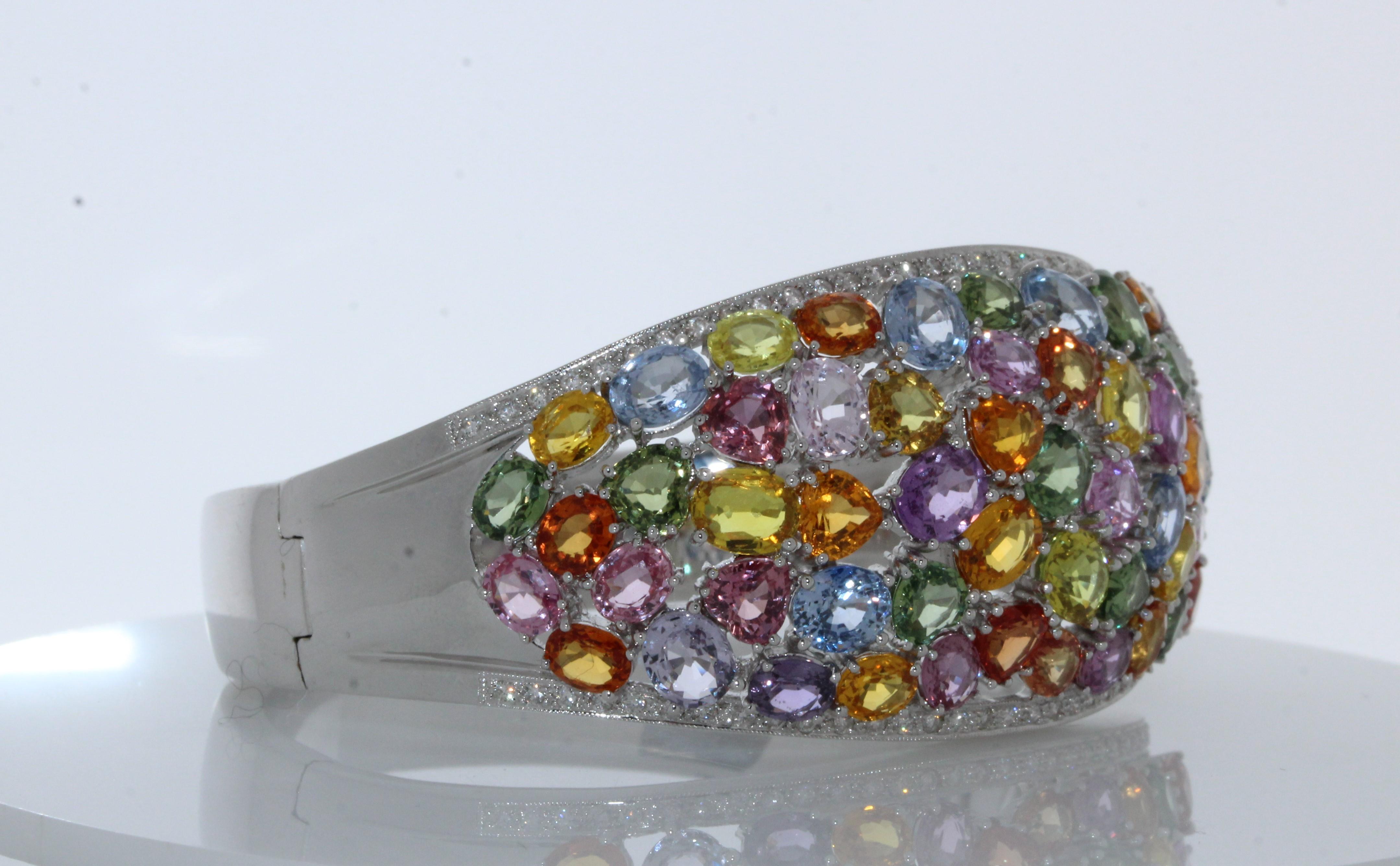 This diamond bracelet features 65carats made up of 65 mixed gemstones. They are colorful and in different colors. It also consists of 80 round diamonds that total up to 1CTW. Created in 18K white gold. This beautiful fancy diamond bracelet closes