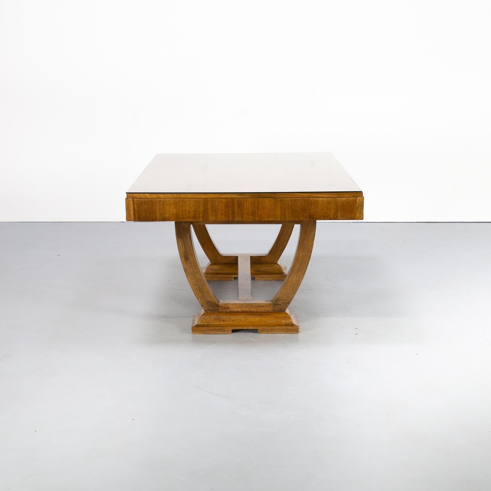 Almost square though rectangle formed beautiful Art Deco early 20st century dining table with glass table top to protect the burl walnut veneer top. The table is very rare because the top is fixed but in the construction it would have been thinkable