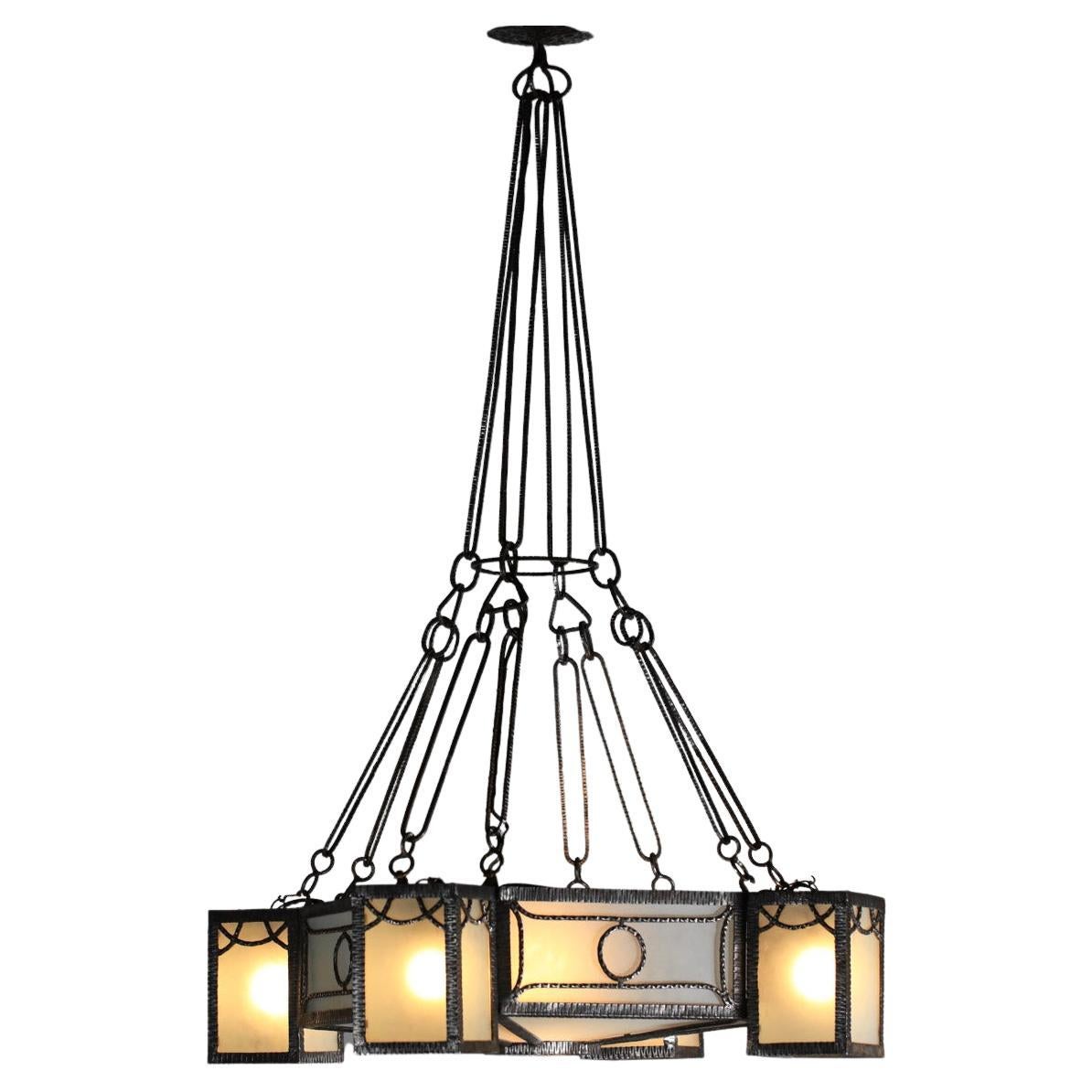 Imposing French art deco chandelier from the 30s. Structure entirely in wrought iron with geometrical patterns and diffusers in frosted glass plates. Very nice vintage condition of the whole hanging, a small dent on one of the plates inside the