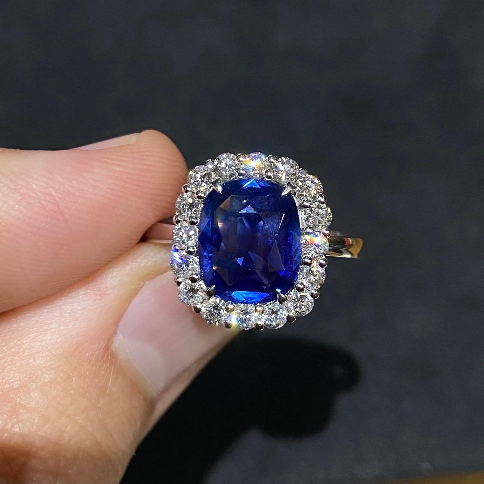 Contemporary 3.10 carats cornflower blue sapphire and diamond cluster engagement ring in 19.2kt white gold, Portuguese, circa 2021. This breathtaking jewel features a certified elongated cushion-cut sapphire of a deep cornflower blue color