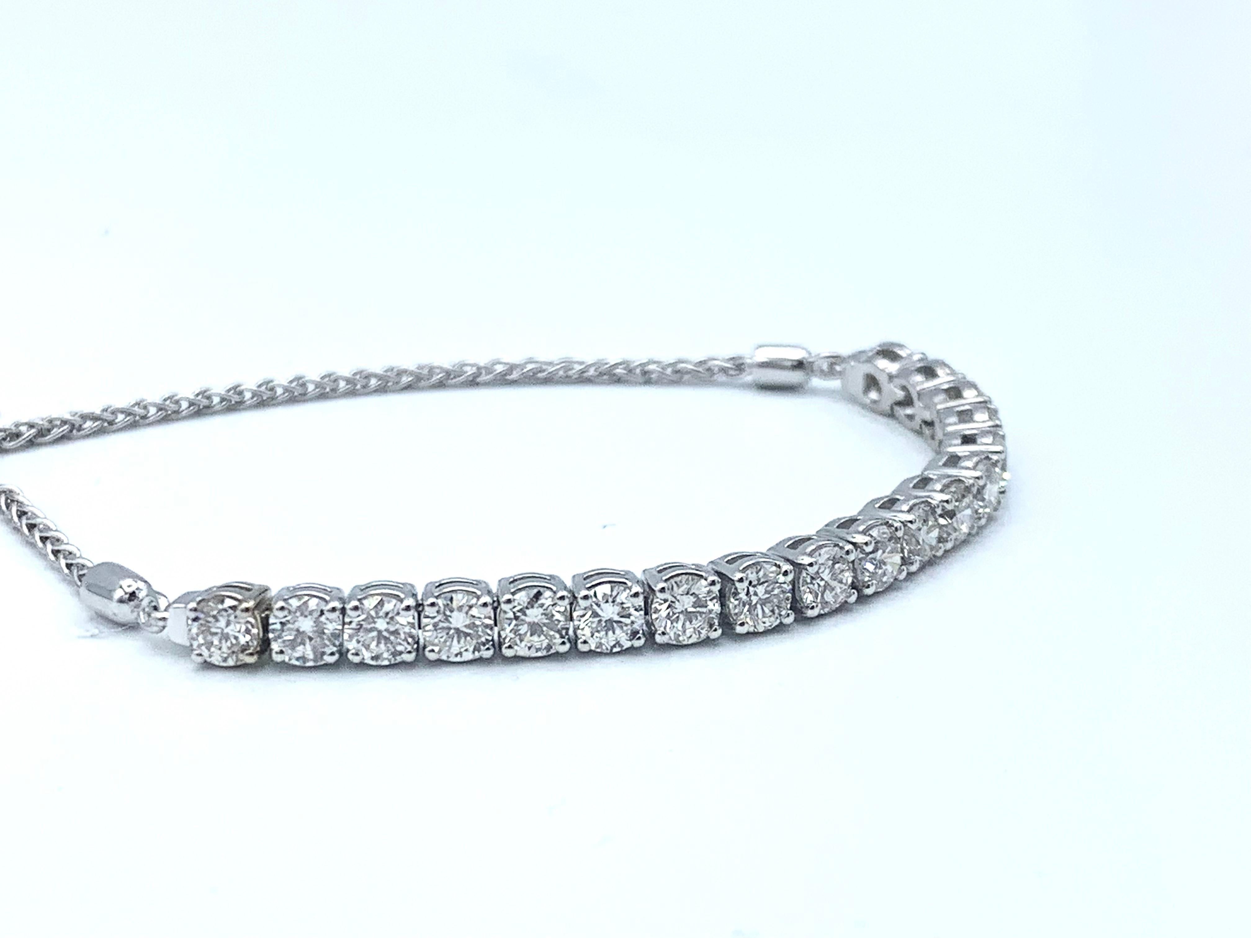 This unique twist on a tennis bracelet consists of 14 karat white gold and 18 round VS2, I-J diamonds totaling 3.1 carats. The bracelet is finished by a 14 karat white gold wheat chain that is adjustable like a draw string with a white gold circle