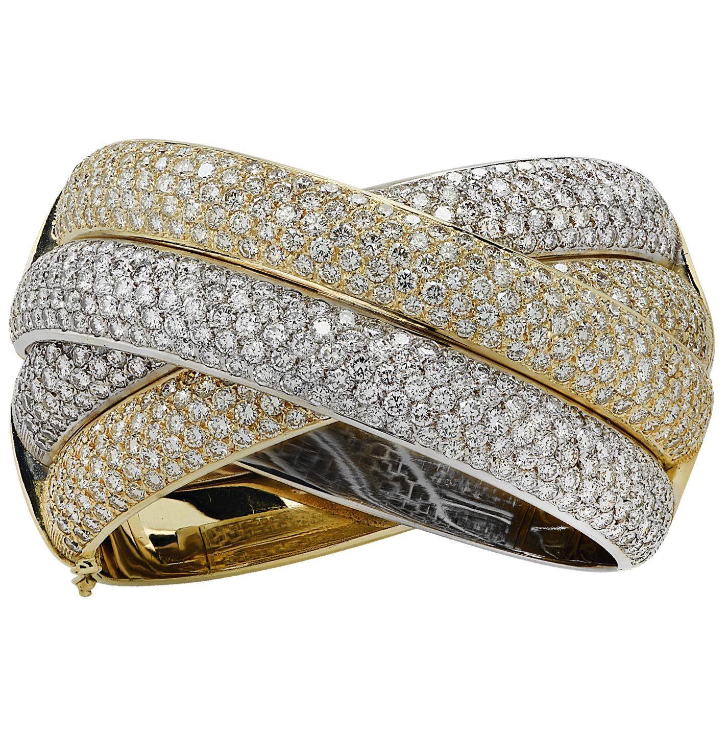 Striking diamond X bangle bracelet crafted in Italy in 18 karat yellow and white gold, featuring 692 round brilliant cut diamonds weighing approximately 31.00 carats total, F-G color, VS-SI clarity. Four diamond encrusted gold strands swirl around
