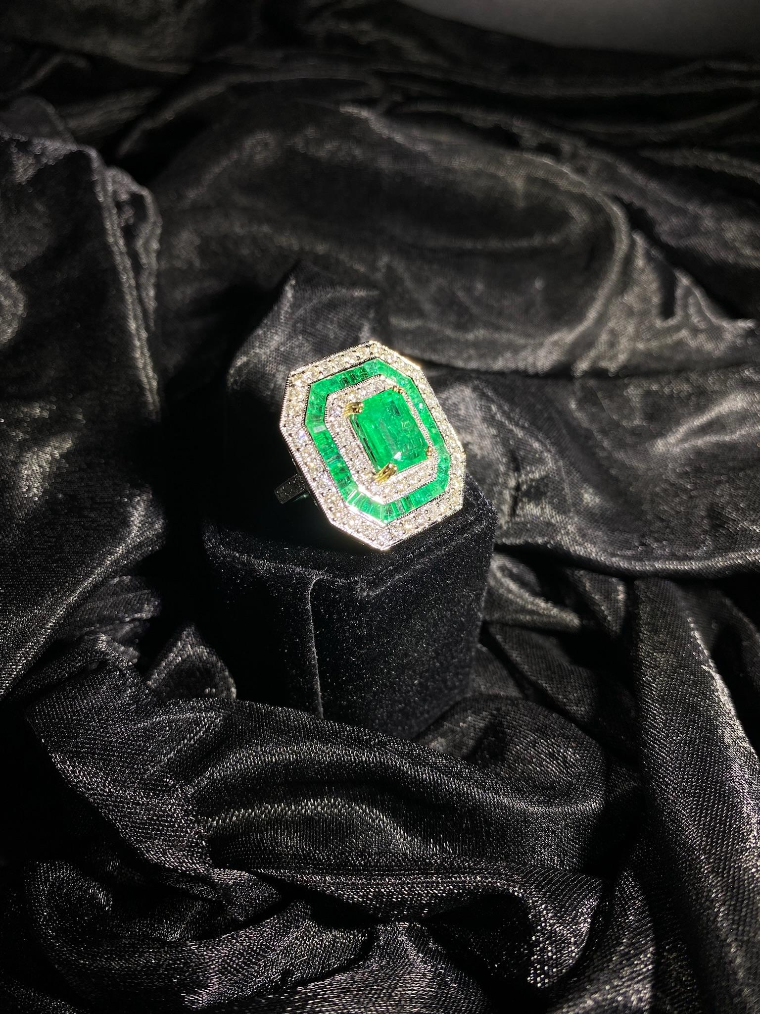 Dieser außergewöhnliche Ring von Iris Fine Jewelry verkörpert mit seiner auffälligen Kombination aus Smaragd und Diamant zeitlose Eleganz. In der Mitte befindet sich ein 3,1 Karat schwerer Smaragd im Smaragdschliff, der in einem lebhaften Grünton