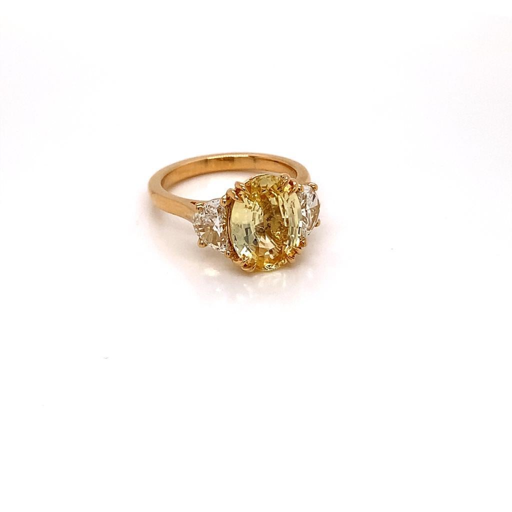 This gorgeous ring features a stunning Oval cut Yellow Sapphire complemented by 2 half-moon diamonds on either side of it and set in an 18K Yellow Gold band. 

The Unheated 3.1 Carat Jewel at the centre of this ring is a flawless Yellow Sapphire
