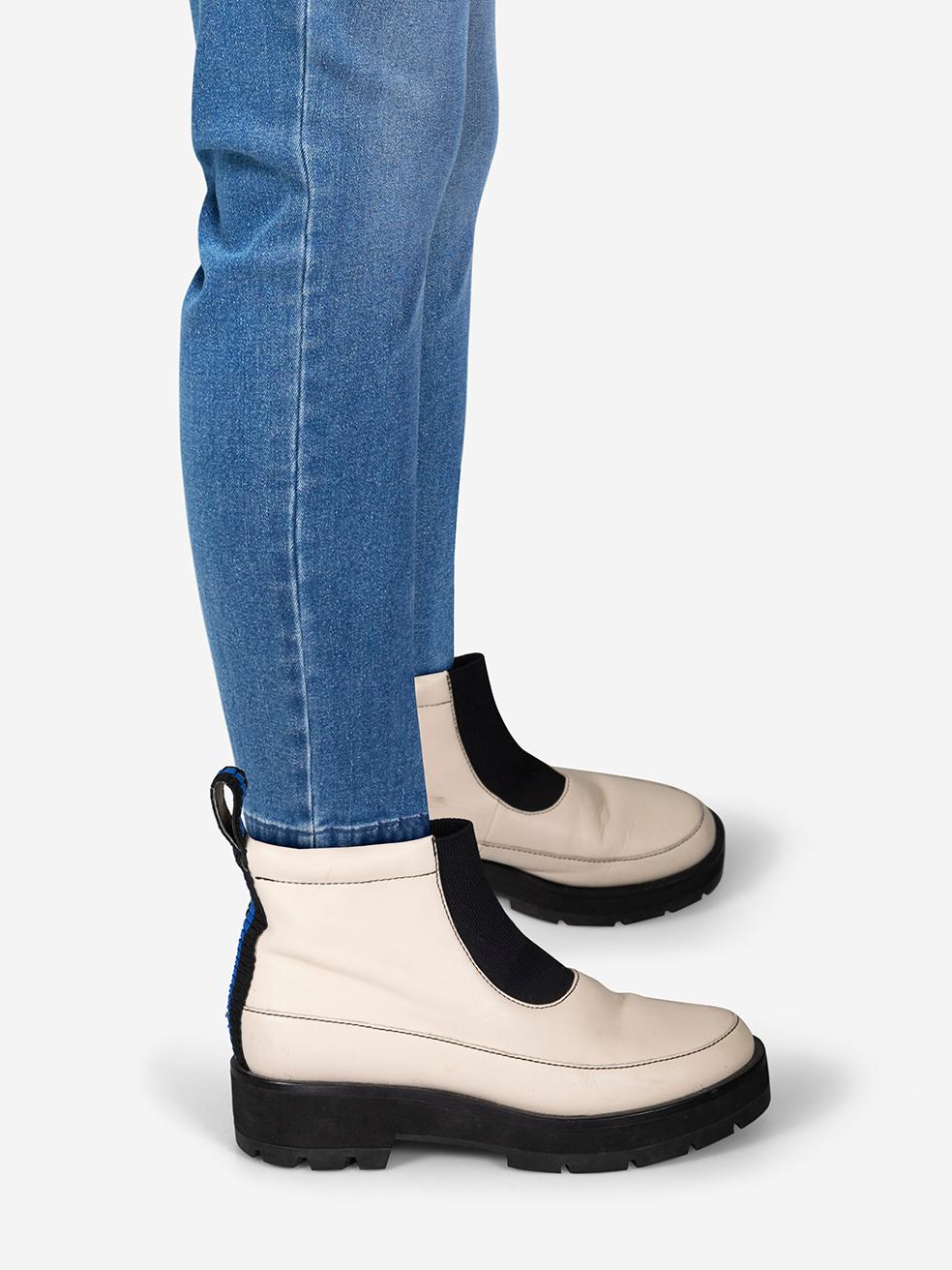 El ESTADO es Bueno. Se aprecia un desgaste menor en las botas. Ambos zapatos presentan marcas de abrasión y decoloración en los laterales y la parte trasera. También se observan arrugas generales en la piel de ambos zapatos y abrasión en la