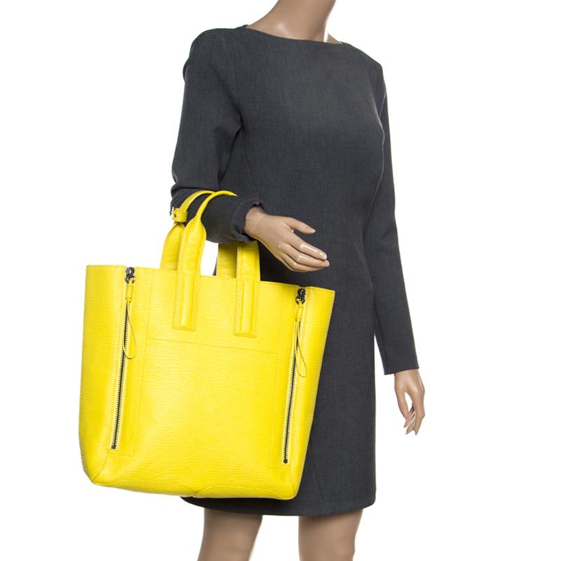 High on appeal and style, this Pashli tote is another illustration of 3.1 Phillip Lim's impeccable craftsmanship. It has been crafted from bright yellow shark-embossed leather and shaped to exude class and grandeur. It is all you need to go about