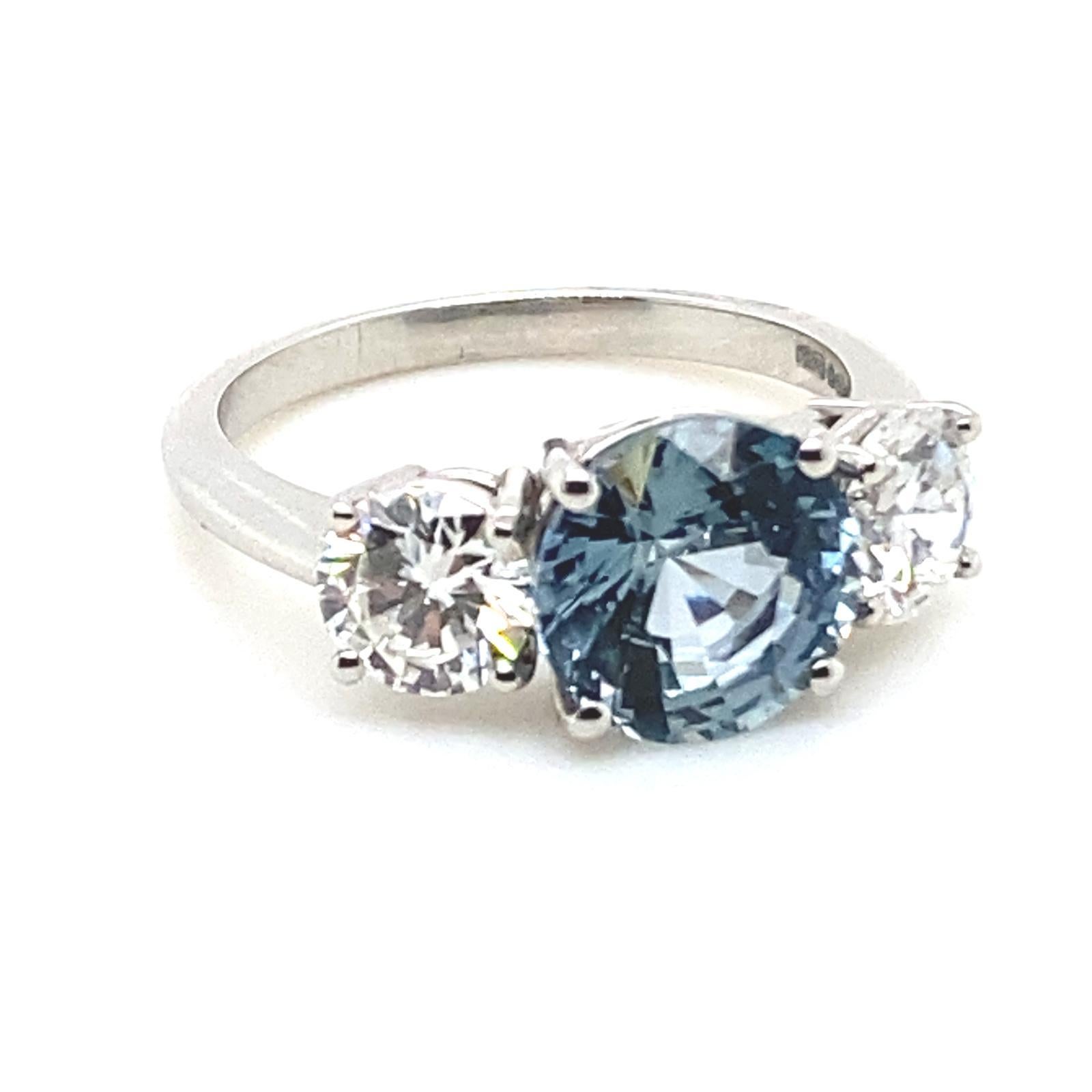 A 3.10 carat sapphire and diamond three stone platinum engagement ring.

This beautiful sapphire and diamond ring is handcrafted in platinum.

Claw set to its centre with a 3.10 carat round cut sapphire of unusual aquamarine colour and framed on