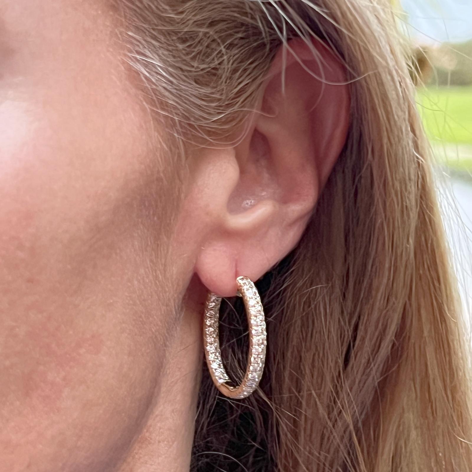 Modern and brilliant diamond hoop earrings crafted in 18 karat yellow gold. The earrings feature round brilliant cut diamonds weighing 3.10 carat total weight and graded G-H color and VS clarity. The diamonds are set in an in & out configuration so