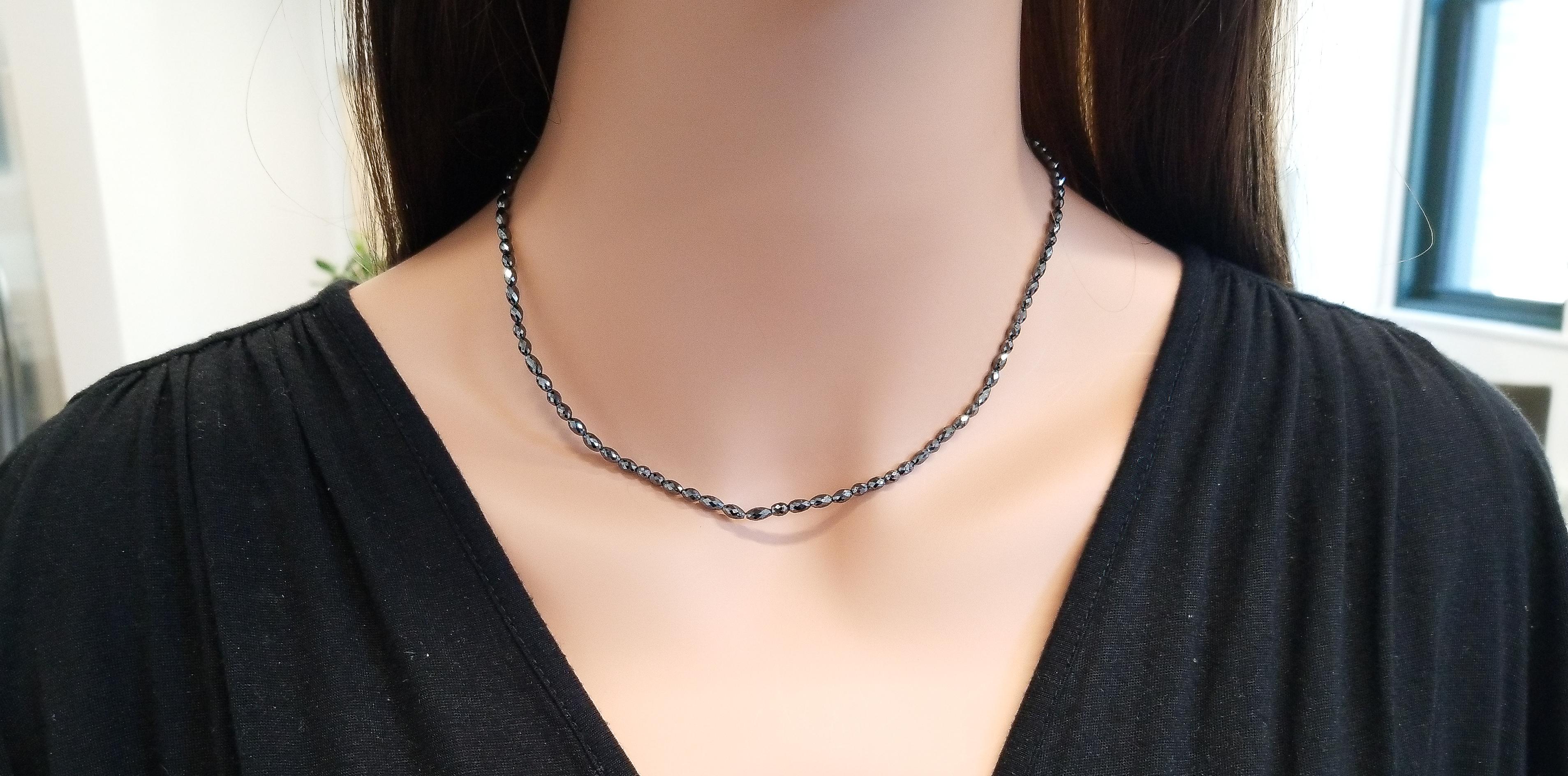 This faceted natural black diamond necklace is distinct and significant. A total of 101 oval shaped beads of fancy vivid black diamonds adorn this stunning tennis necklace totaling an impressive 32 carats. This diamond necklace closes with an oval