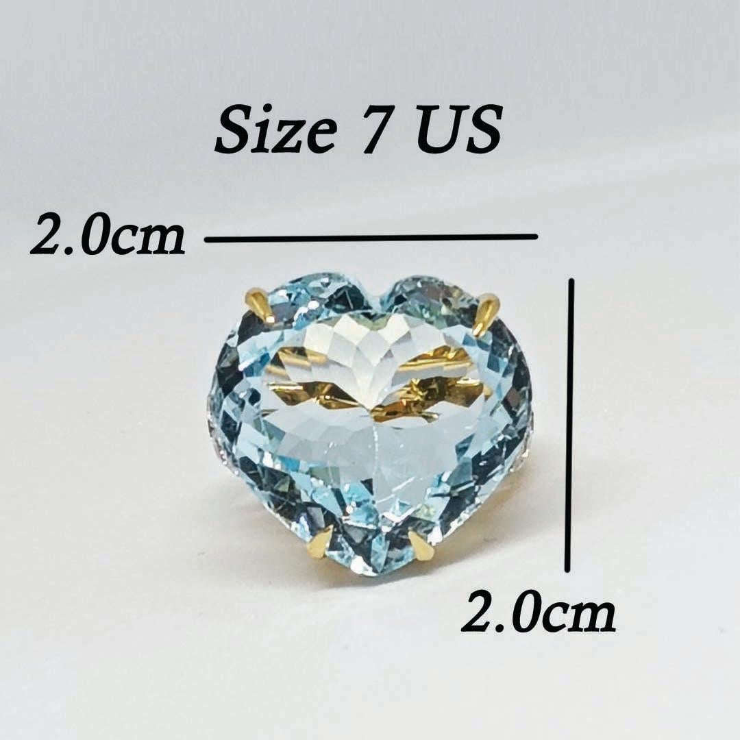 Topazio blu a forma di cuore 20,5x19,4 x10 mm. 31,00 carati.
Zircone bianco da 2,5 mm. 18 pezzi.
Argento 925 placcato oro 18 carati.
Anello misura 7 US.



