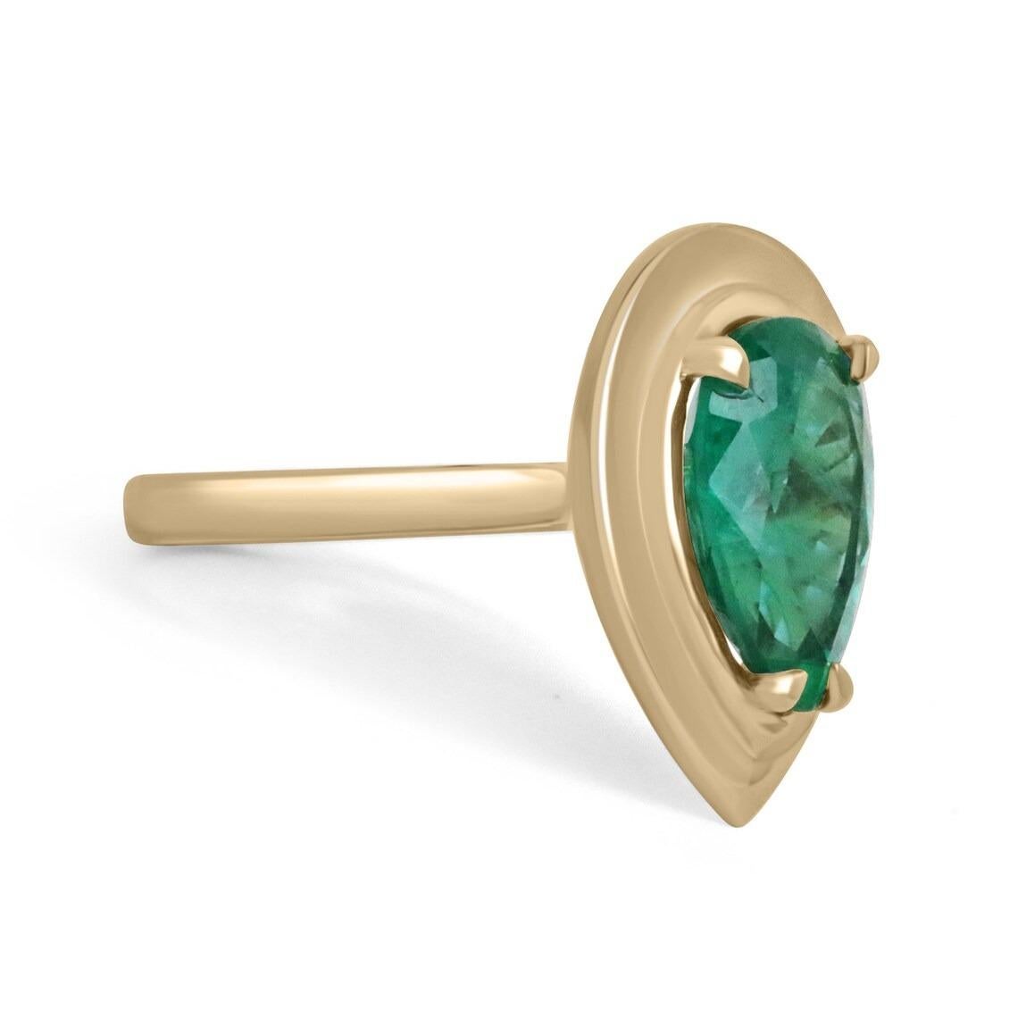 Displayed is a dark green emerald prong set, teardrop solitaire ring in 18K gold. This gorgeous solitaire ring carries a full 3.10-carat emerald that has ideal color and very good eye clarity. Minor imperfections are normal as this emerald is a