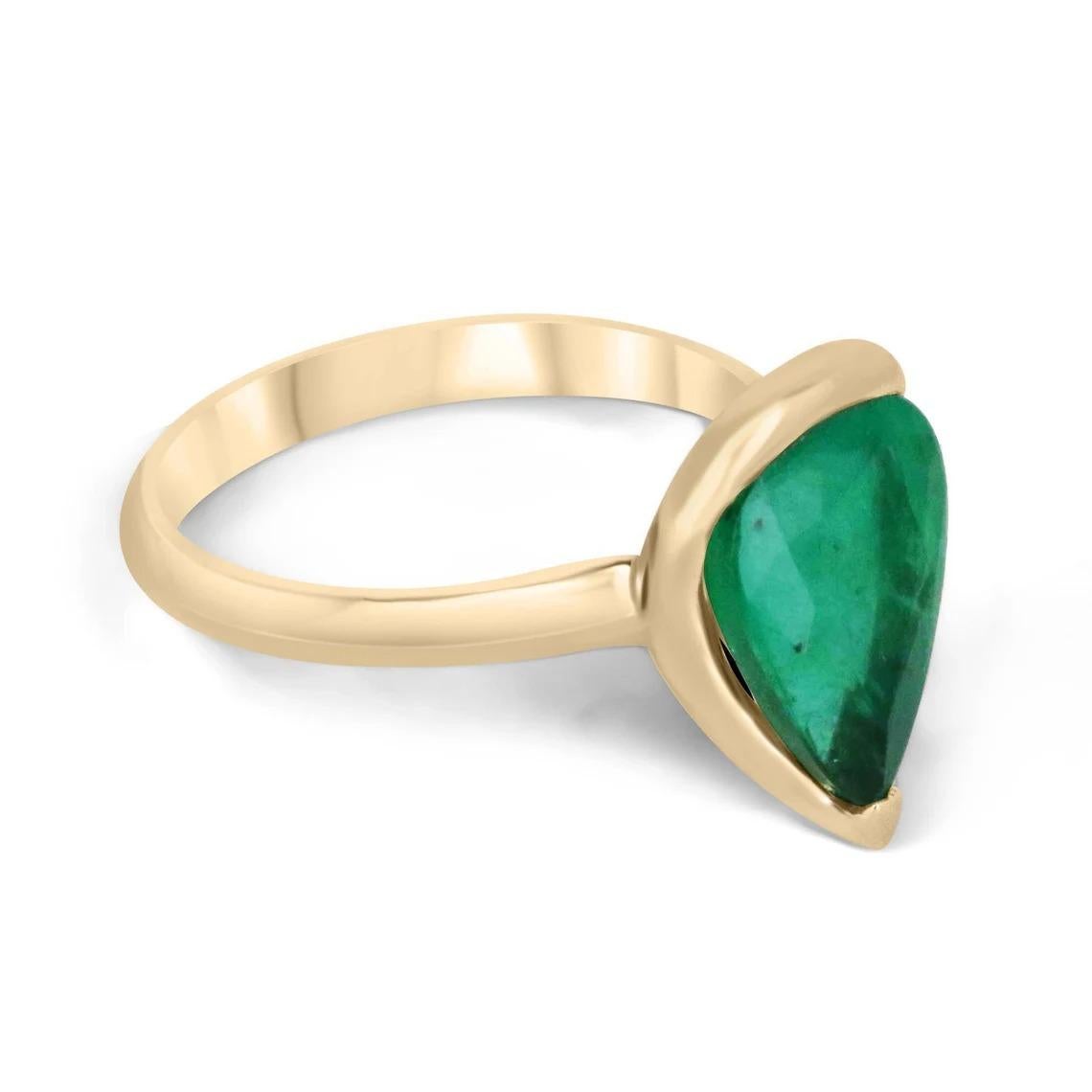 Introducing a breathtaking solitaire emerald ring that exudes elegance and luxury. The centerpiece of this exquisite piece is a magnificent 3.10-carat pear-cut Colombian emerald, showcasing a captivating rich dark green color. Its natural internal