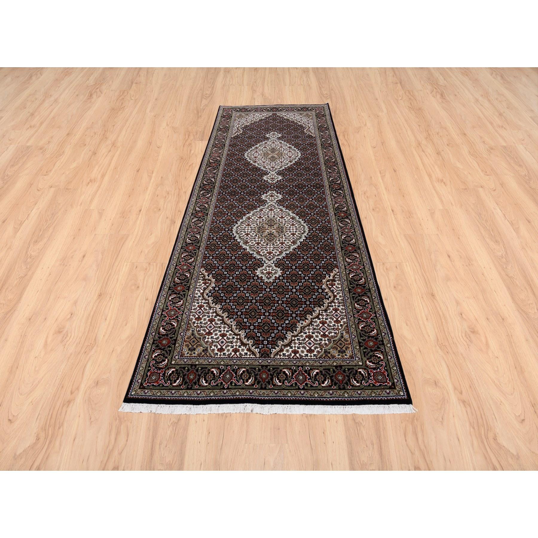 This is a truly genuine one-of-a-kind Wool Black Tabriz Mahi with Fish Medallions Design Hand Knotted Wide Runner Oriental Rug. It has been woven for months and months in the centuries-old Persian weaving craftsmanship techniques by expert