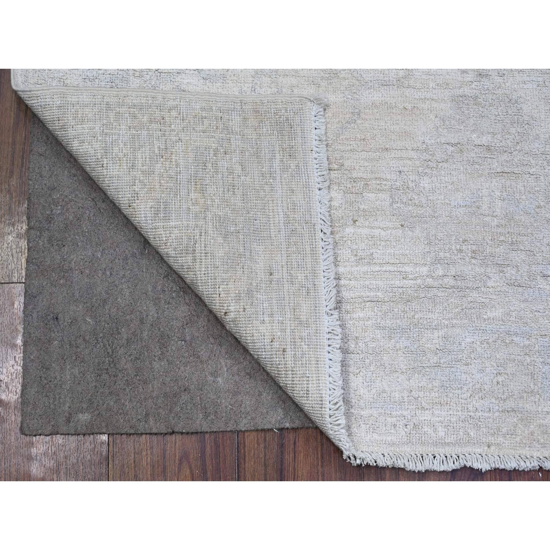Se trata de una auténtica alfombra oriental de lana suave y aterciopelada, anudada a mano, de color blanco con diseños desteñidos. Ha sido anudada durante meses y meses con técnicas artesanales de tejido centenarias por expertos