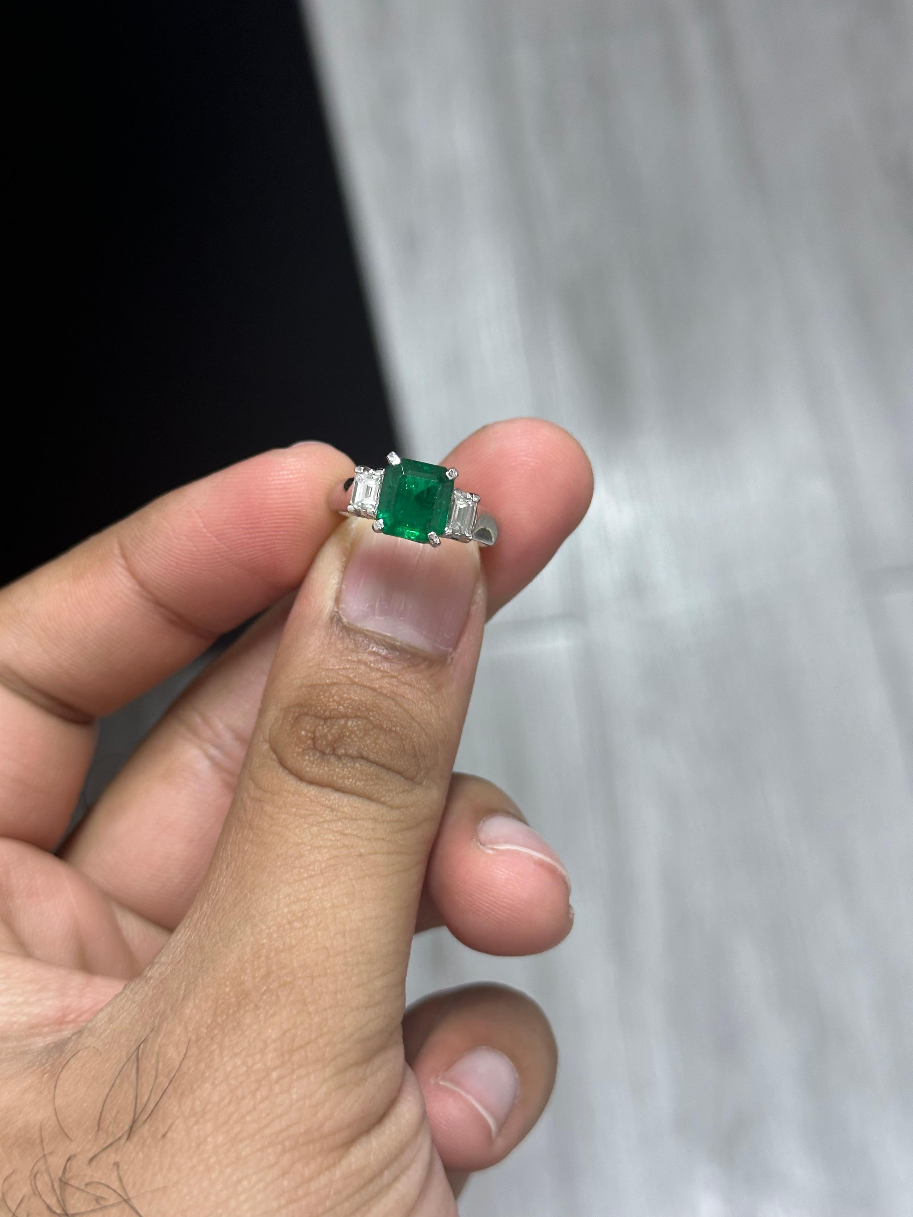 Introducing the epitome of luxury and sophistication, behold the breathtaking three-stone, Emerald and Diamond Ring, a true marvel in the world of fine jewelry. Crafted with precision and passion, this extravagant piece exudes opulence from every