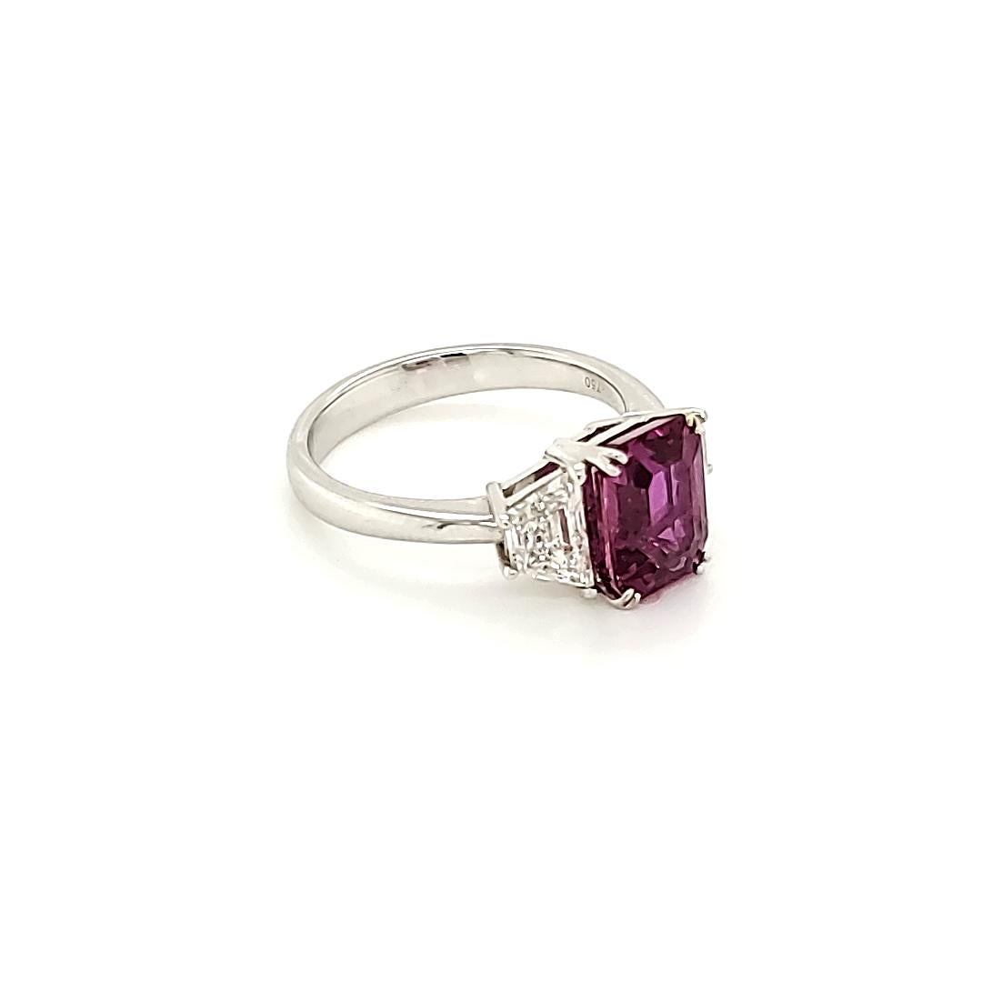 3.11 Carat Emerald Cut Pink Sapphire And Diamond White Gold Engagement Ring:

A scintillating Emerald Cut Pink Sapphire weighing 3.11 carat accented by two Trapezoid Cut White Diamonds of F Colour and VS Clarity weighing 1.21 carat. The Pink