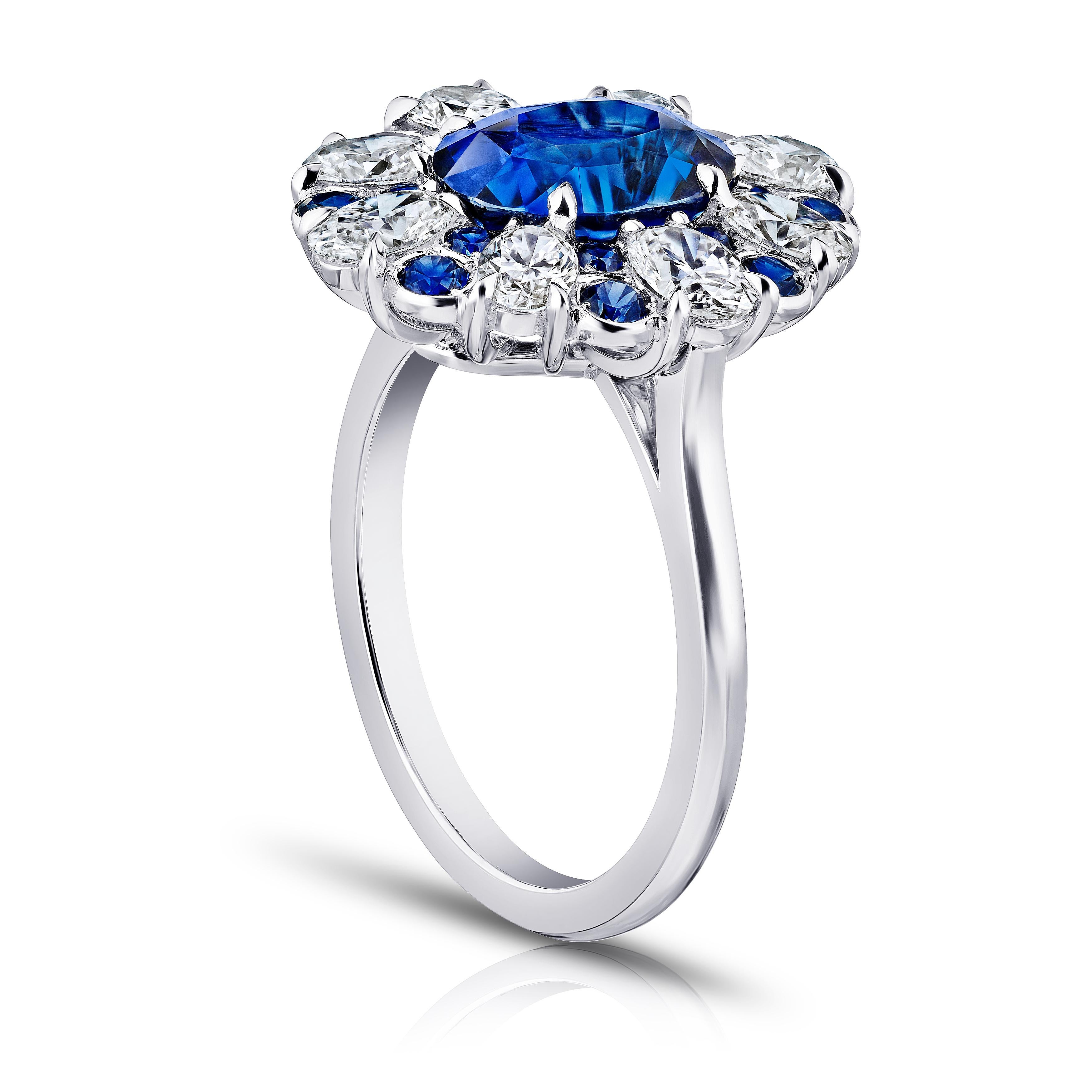3.11 carat oval blue sapphire with eight oval diamonds 1.44 carats and 16 round sapphires .54 carats set in a platinum ring.