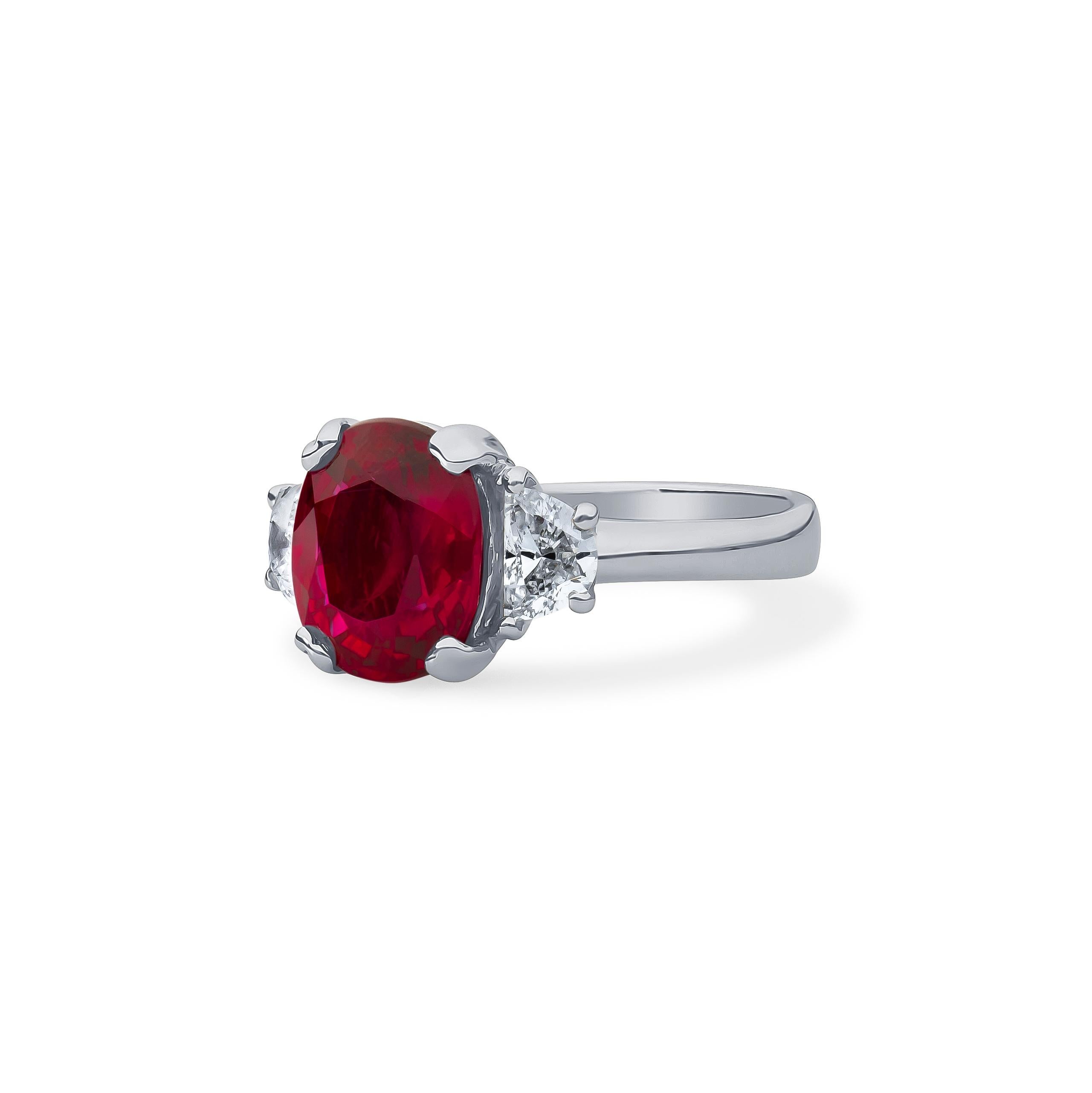 Platinum three-stone ring set with one 3.11 carat oval cut natural Thai ruby, comes with its very own certification from the AGL laboratory, and approximately 0.50 carats total weight in two half moon diamonds set on both sides of the ruby. The ring